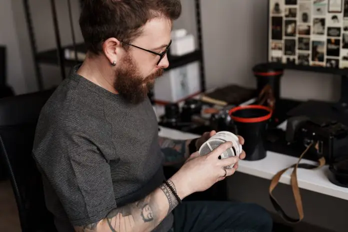 Male photographer analyzing film negatives in studio