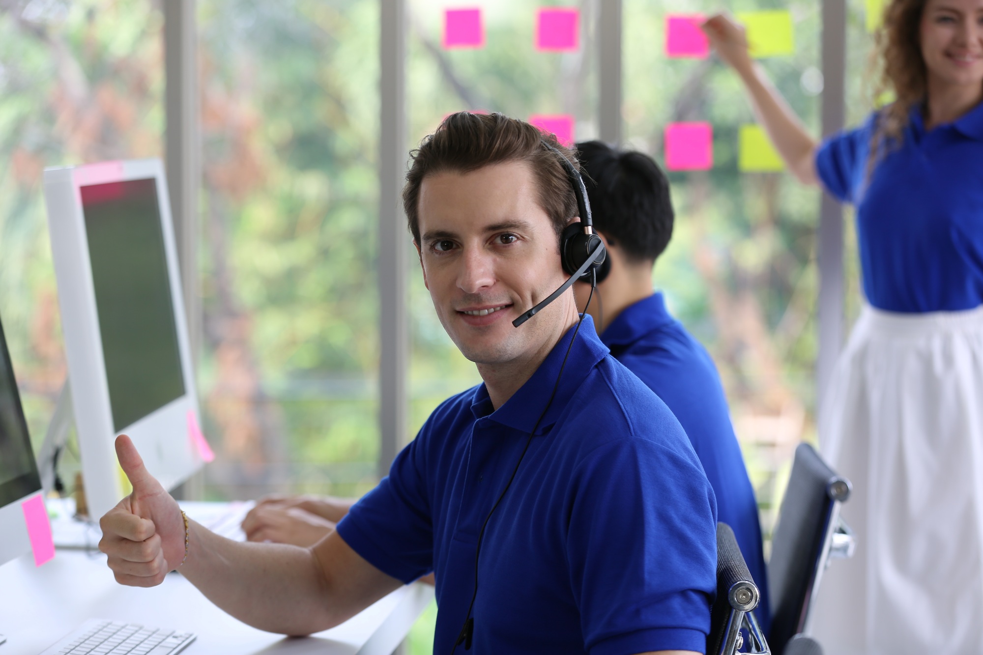 male tech support operator with blue t-shirt uniform and black headset