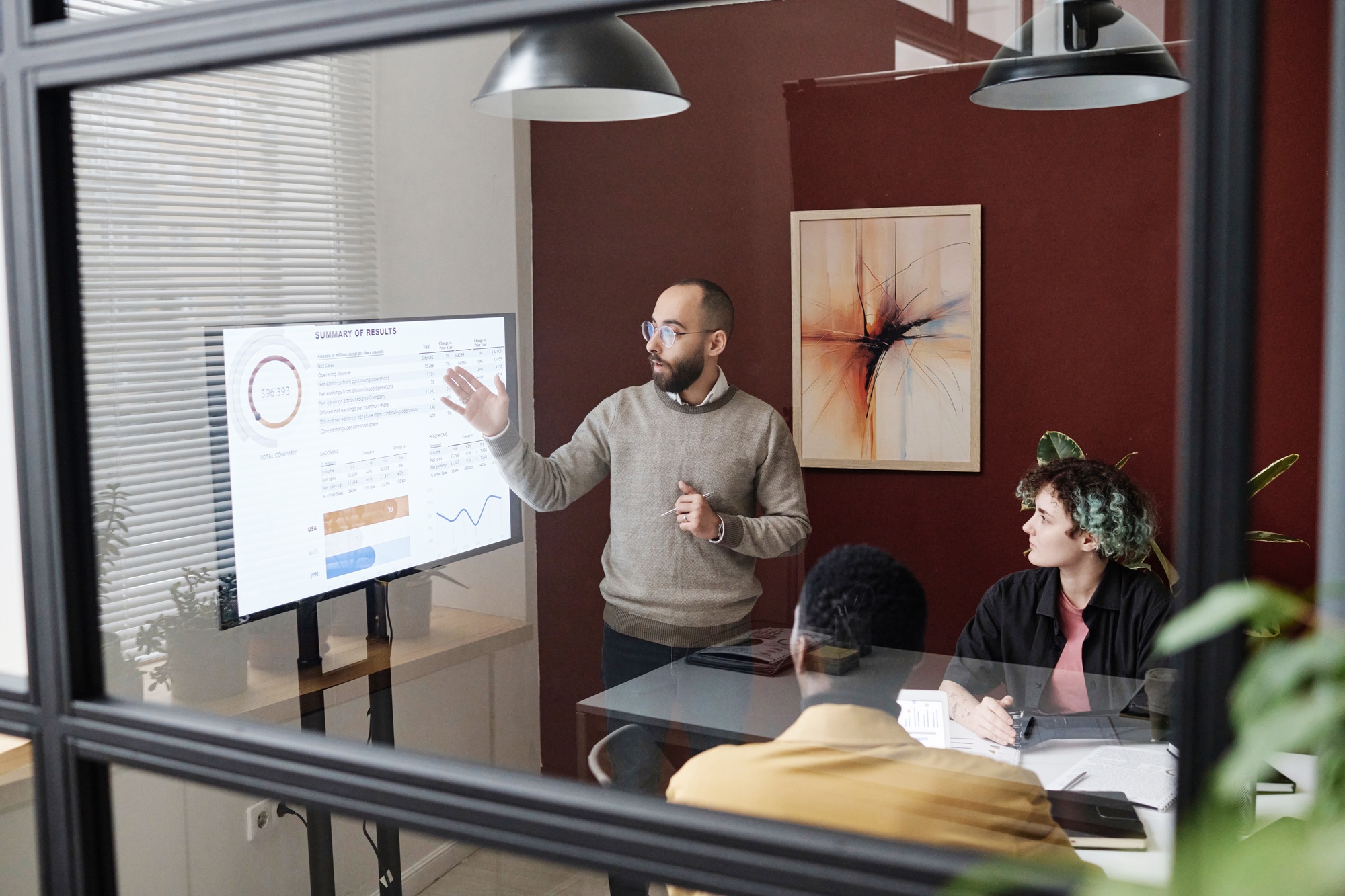 Man Giving Speech While Demonstrating Infographics to His Colleagues