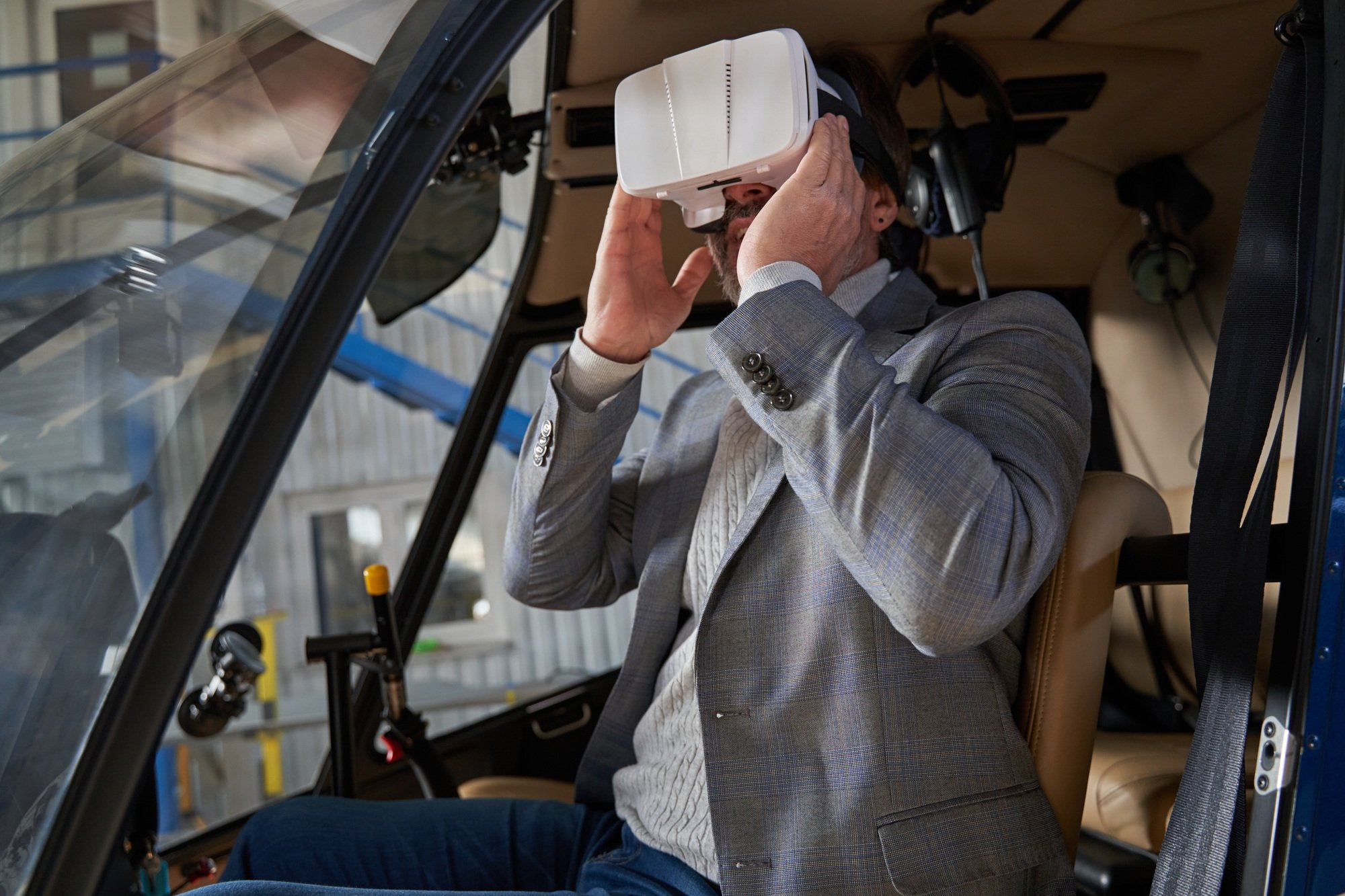 Man playing a 3D simulation game in hangared chopper
