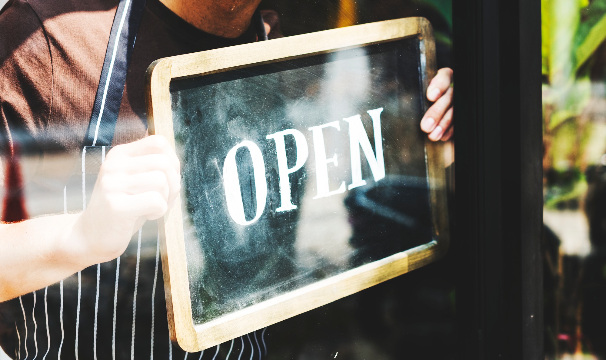 Man putting on shop open sign