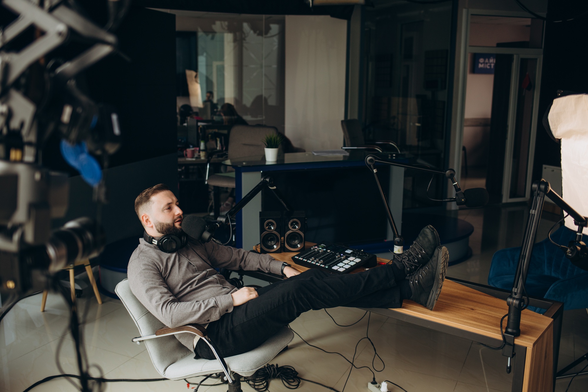 Man radio host or representer or journalist reads news from paper list in hand to studio microphone