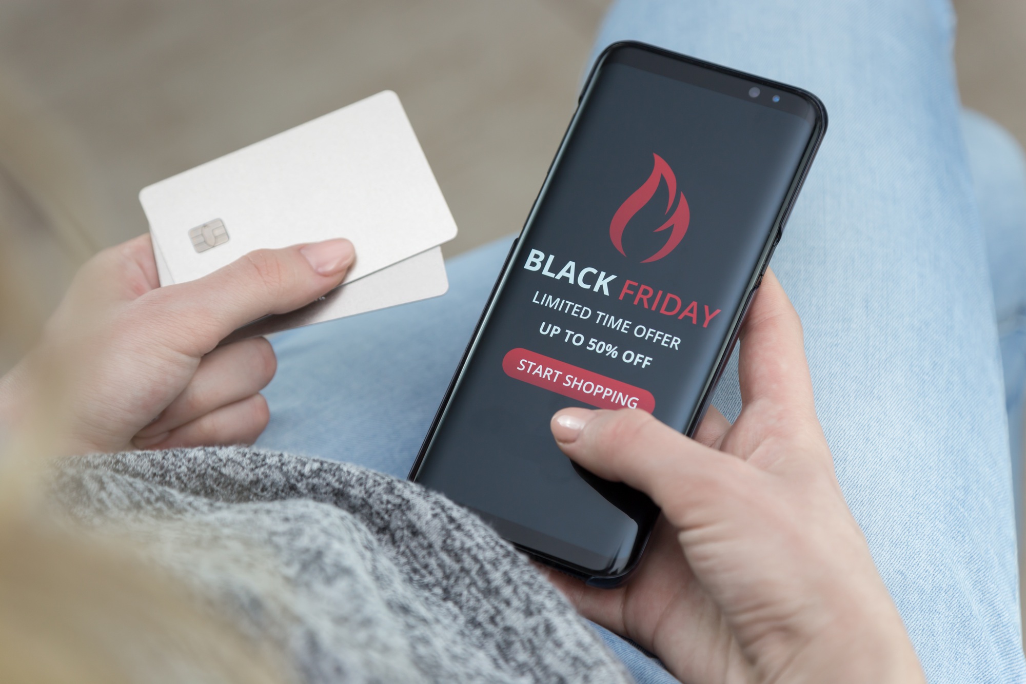 Mobile phone with Black Friday advertisement on the screen in female hands
