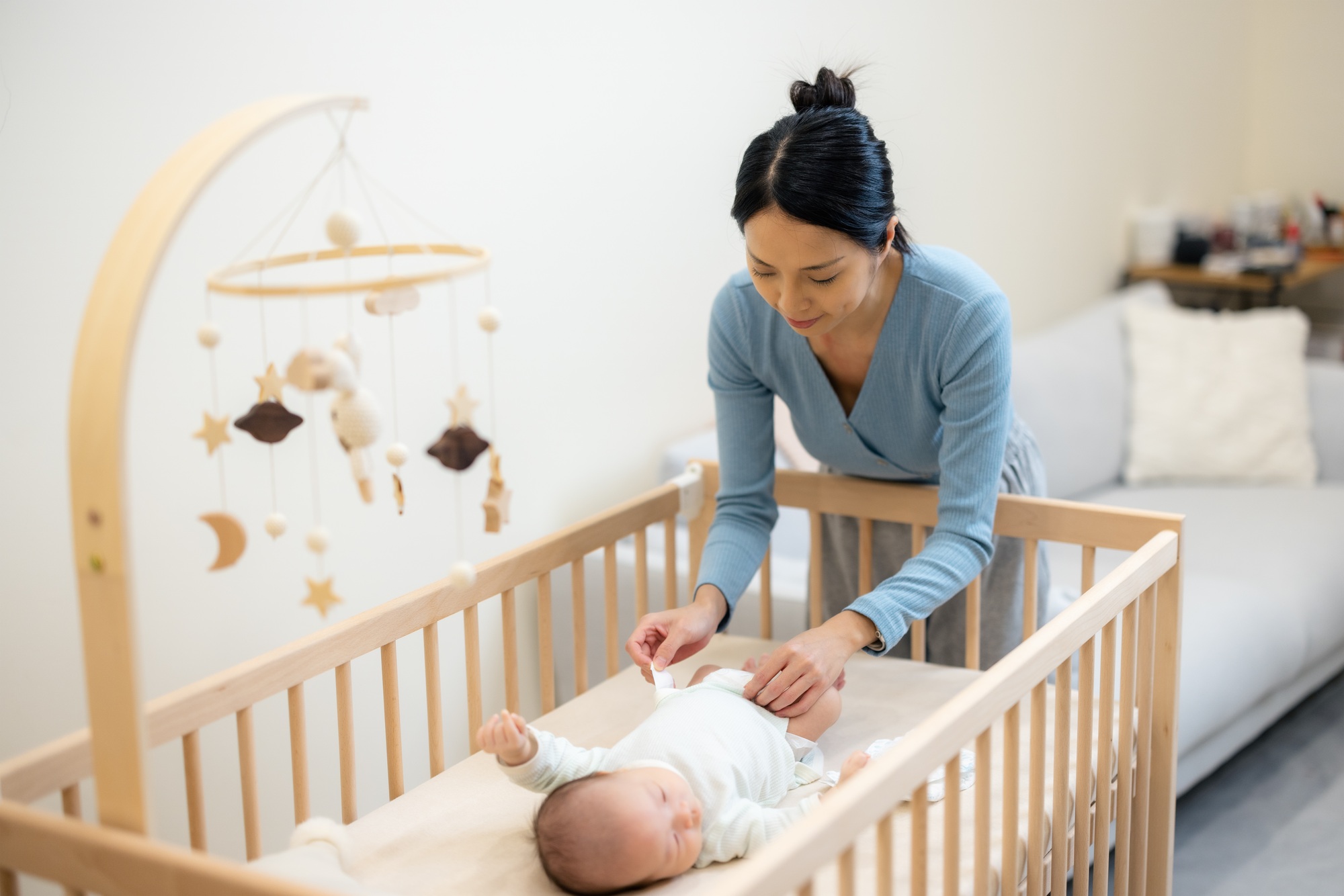 Mom helping to change her baby diaper