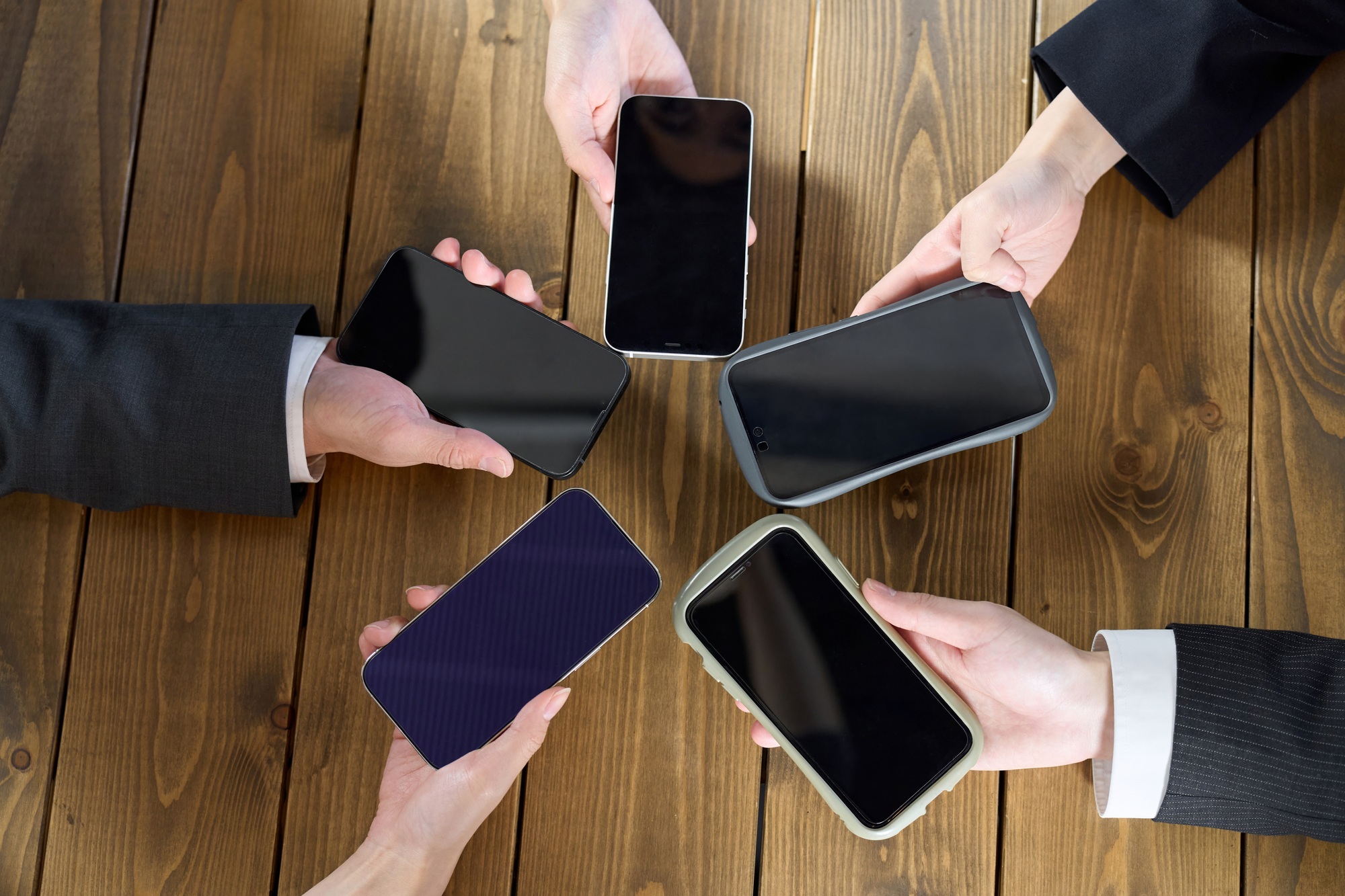 Multiple business people holding smartphones