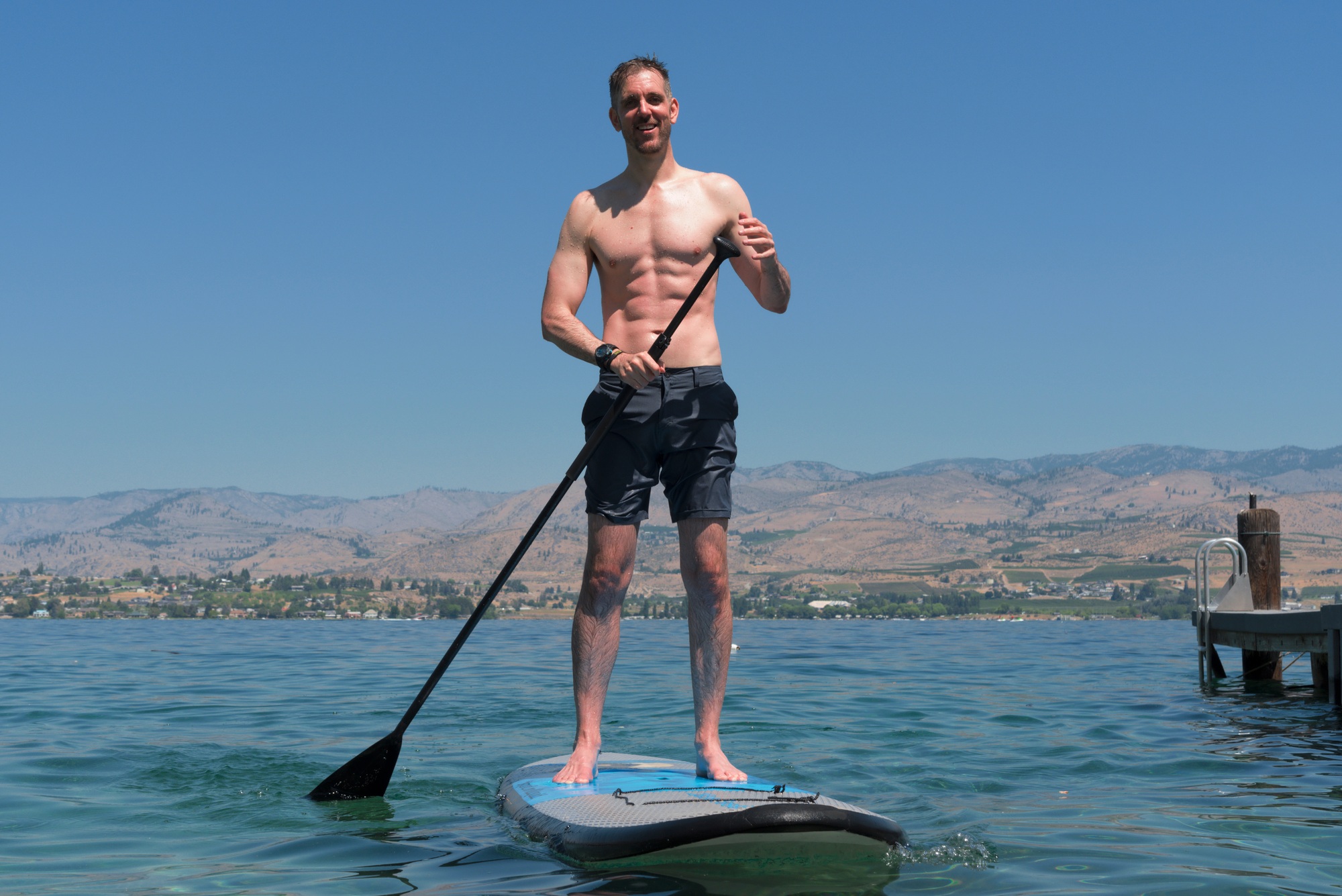 Muscular man on paddle board.