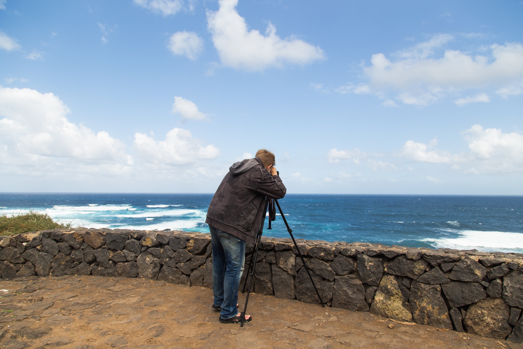 Nature, photographer and videographer concept - Man taking pictures and shooting video of sea