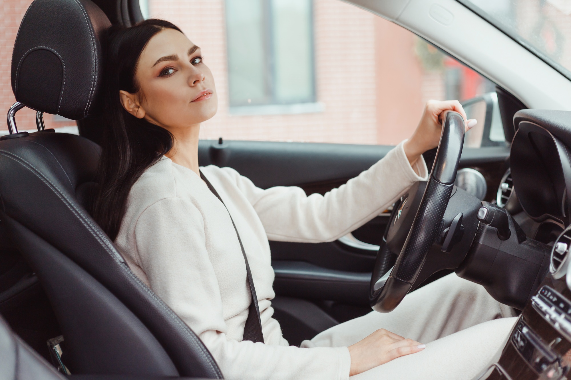 Photo of happy young woman sitting inside her new car. Concept for car rental