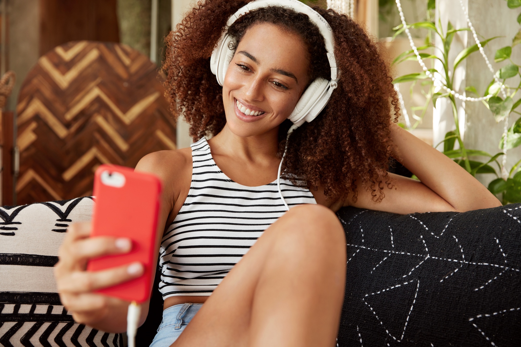 Portrait of happy female blogger publishes new photos on website, makes selfie on modern smart phone