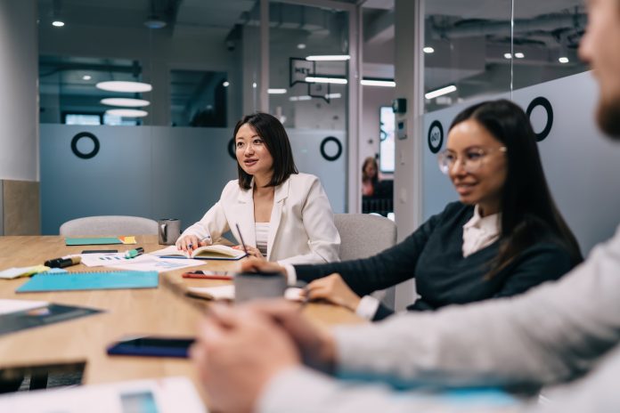 Positive diverse colleagues discussing business plan in conference room