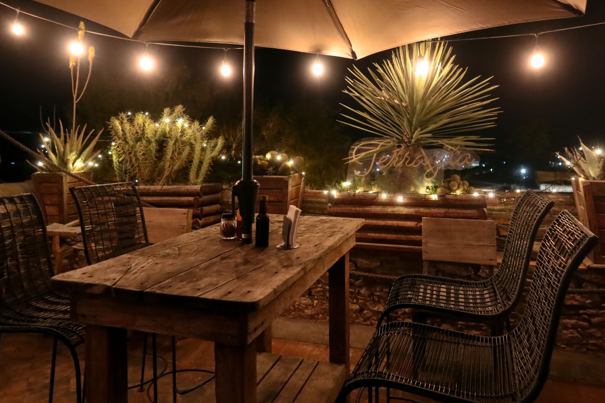 Rustic restaurant table in Mexican town, with lights at night