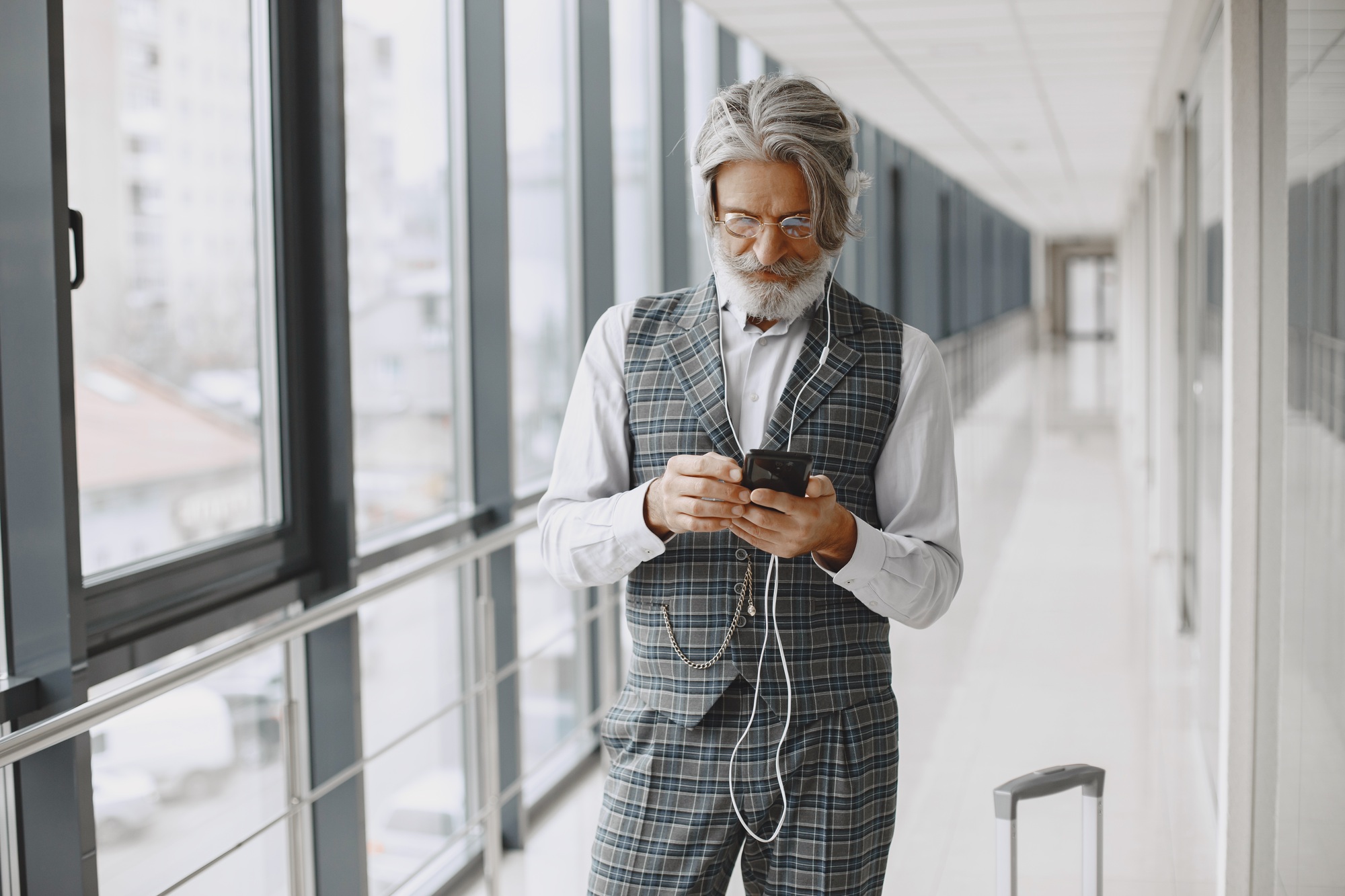 Senior businessman with travel suitcase in airport