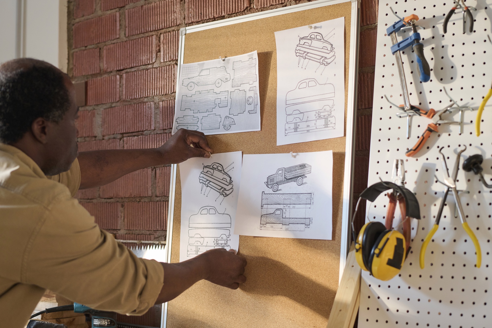 Senior Carpenter Hanging Woodworking Plans in Workshop