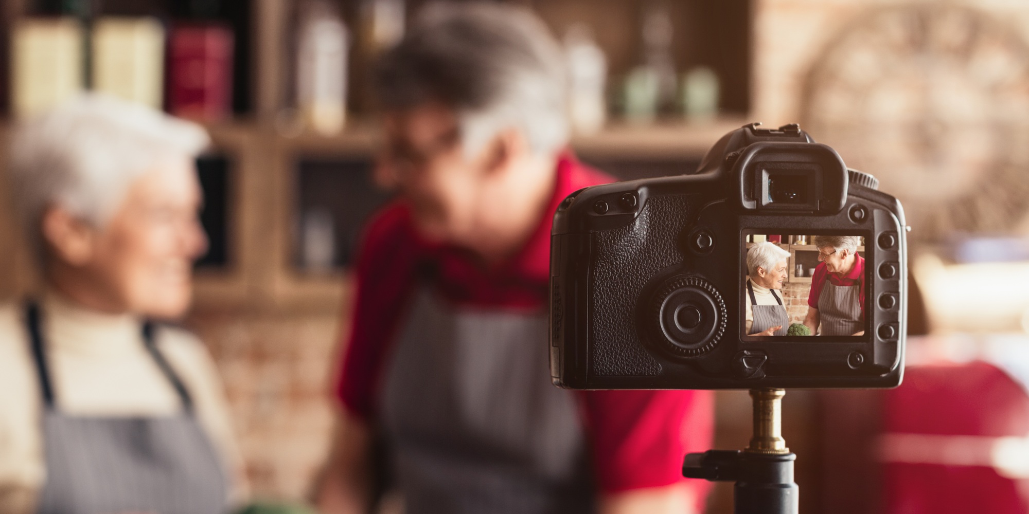 Senior Couple Smiling While Filming Cooking Video in Home Kitchen