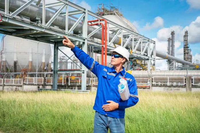 Senior Engineer wearing safety jacket and PPE working about Petrochemica Chemical Prodiction impo