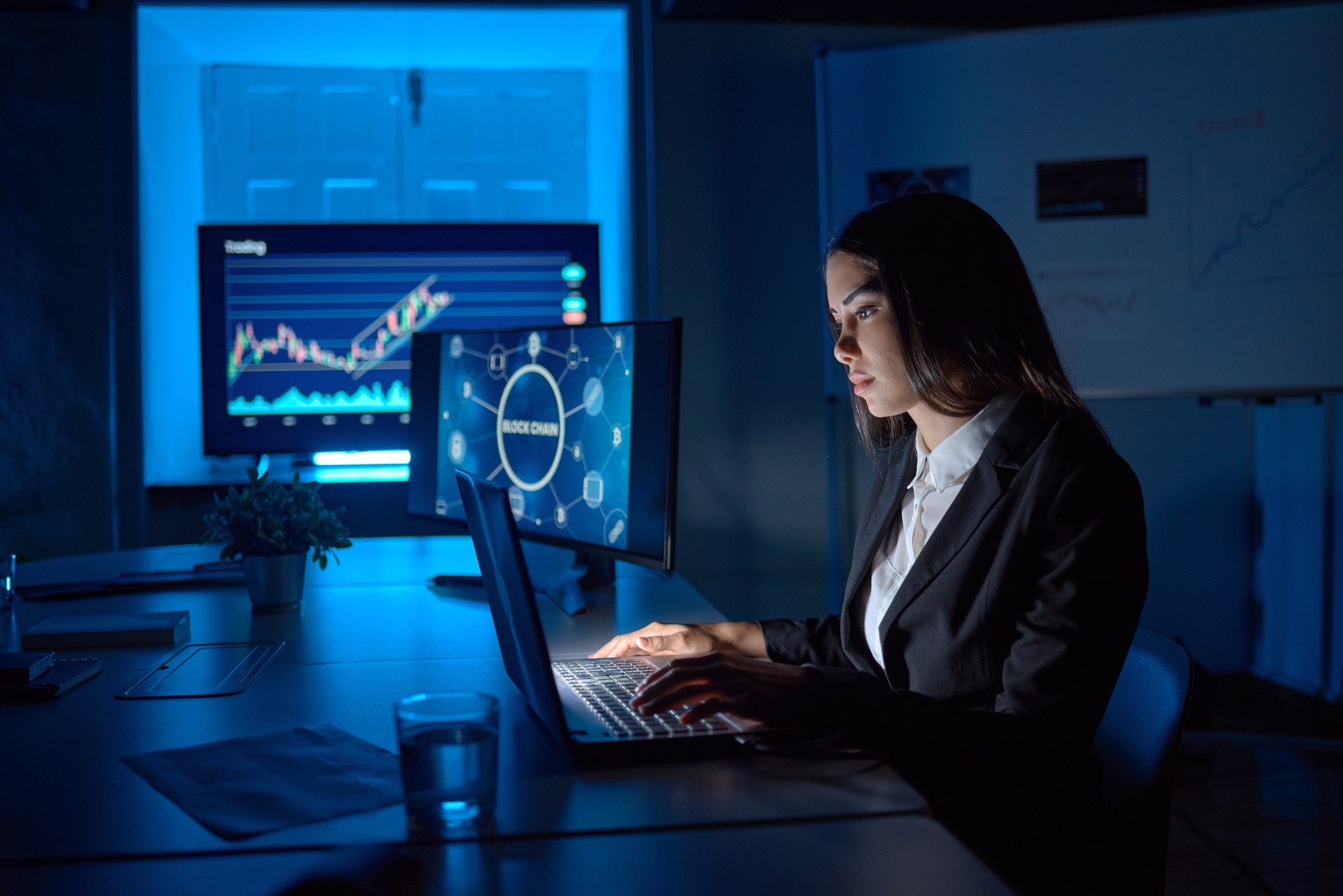 Serious employee typing on laptop while analyzing data in office