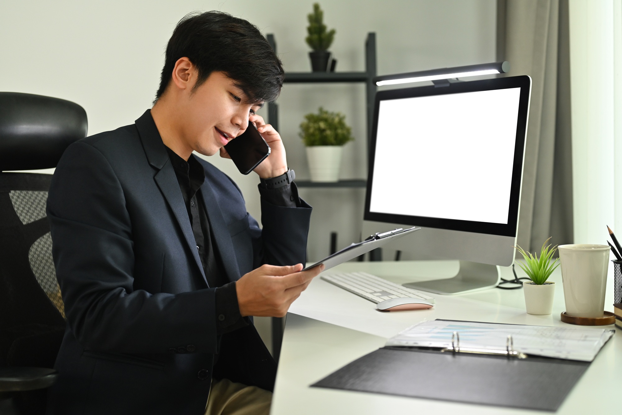 Shot of marketing sales manager talking on mobile phone at his workstation.