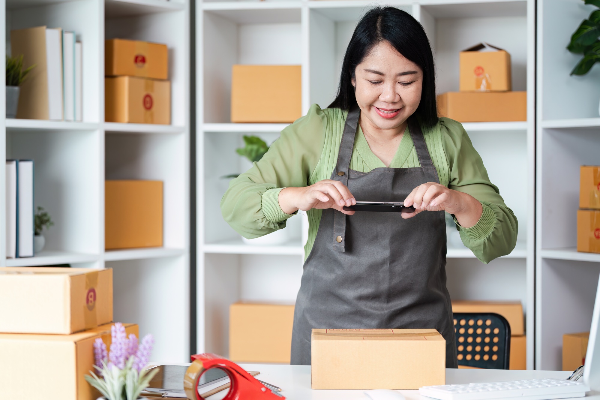 Small Business Owner Packaging Products in Office with Shelves and Boxes