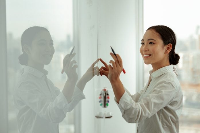 Smart asian business woman write project plan on flipboard during meeting