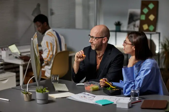 Smiling Business People Enjoying Late Snack in Office