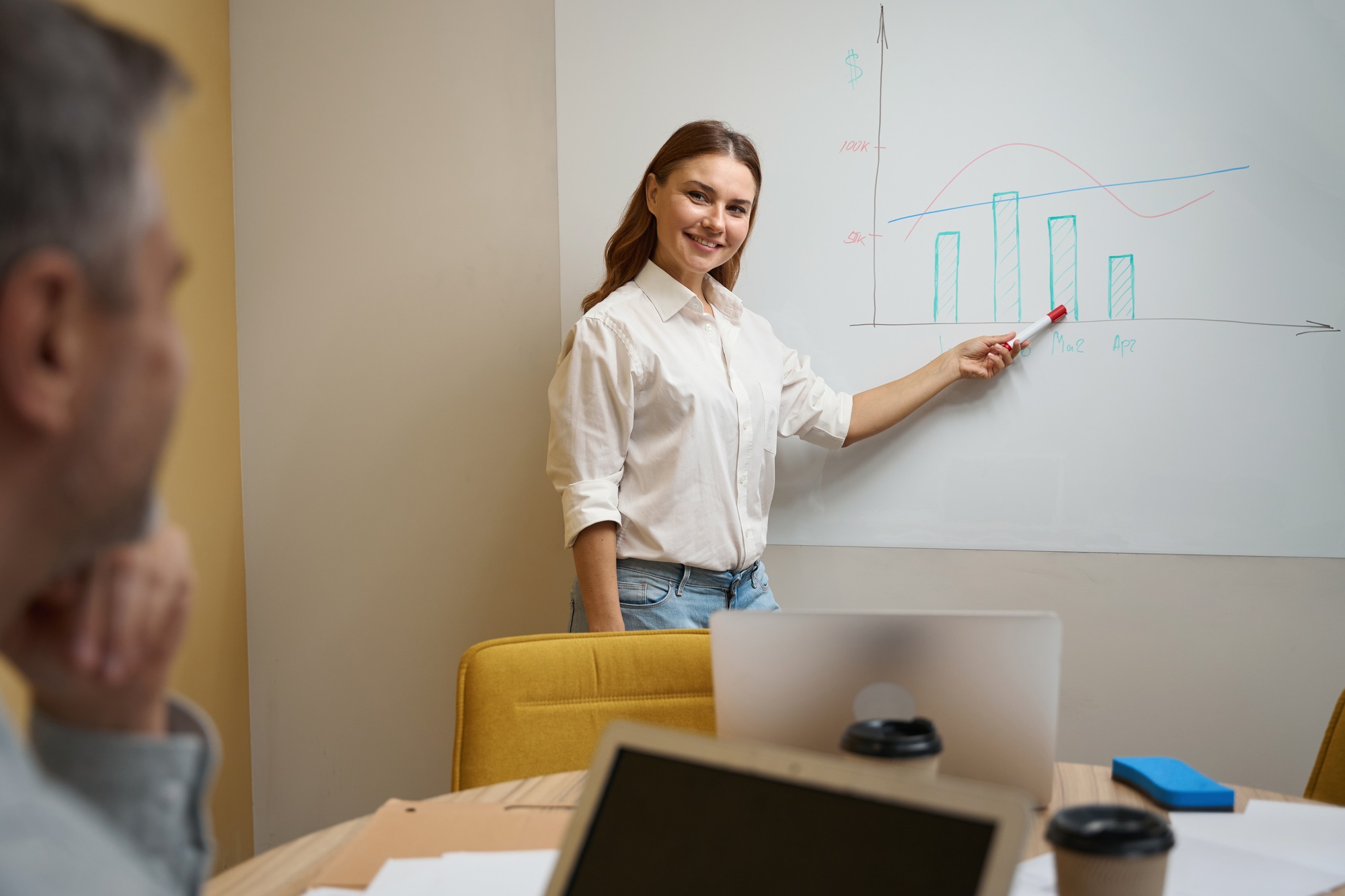 Smiling female in office clothes telling employee about sales