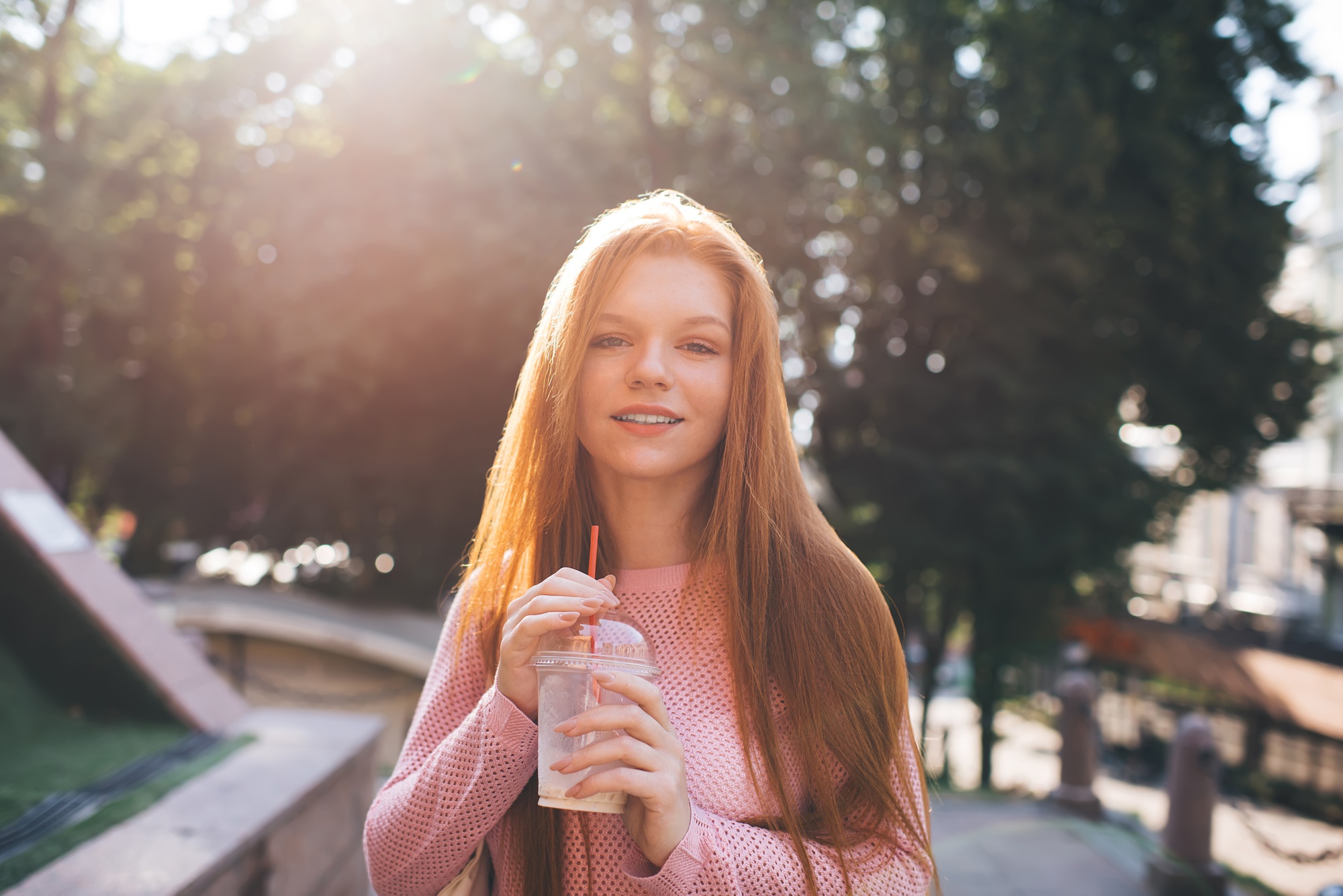 Smiling woman standing with lemonade bottle