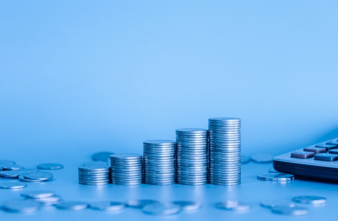 Stack of money coin with copy space. Business and finance background with blue filter.