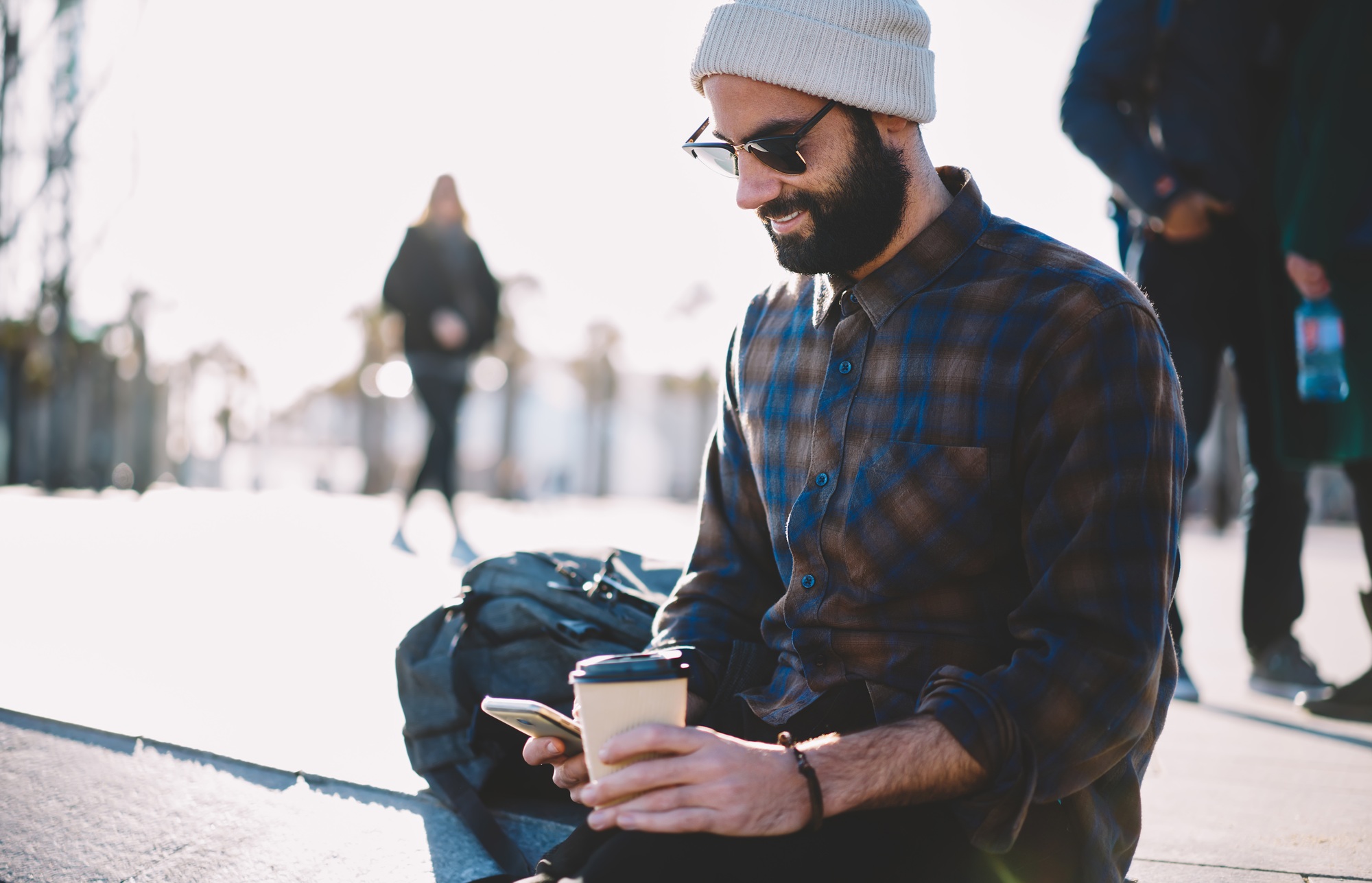 Stylish male blogger with coffee to go publishing new post on media website
