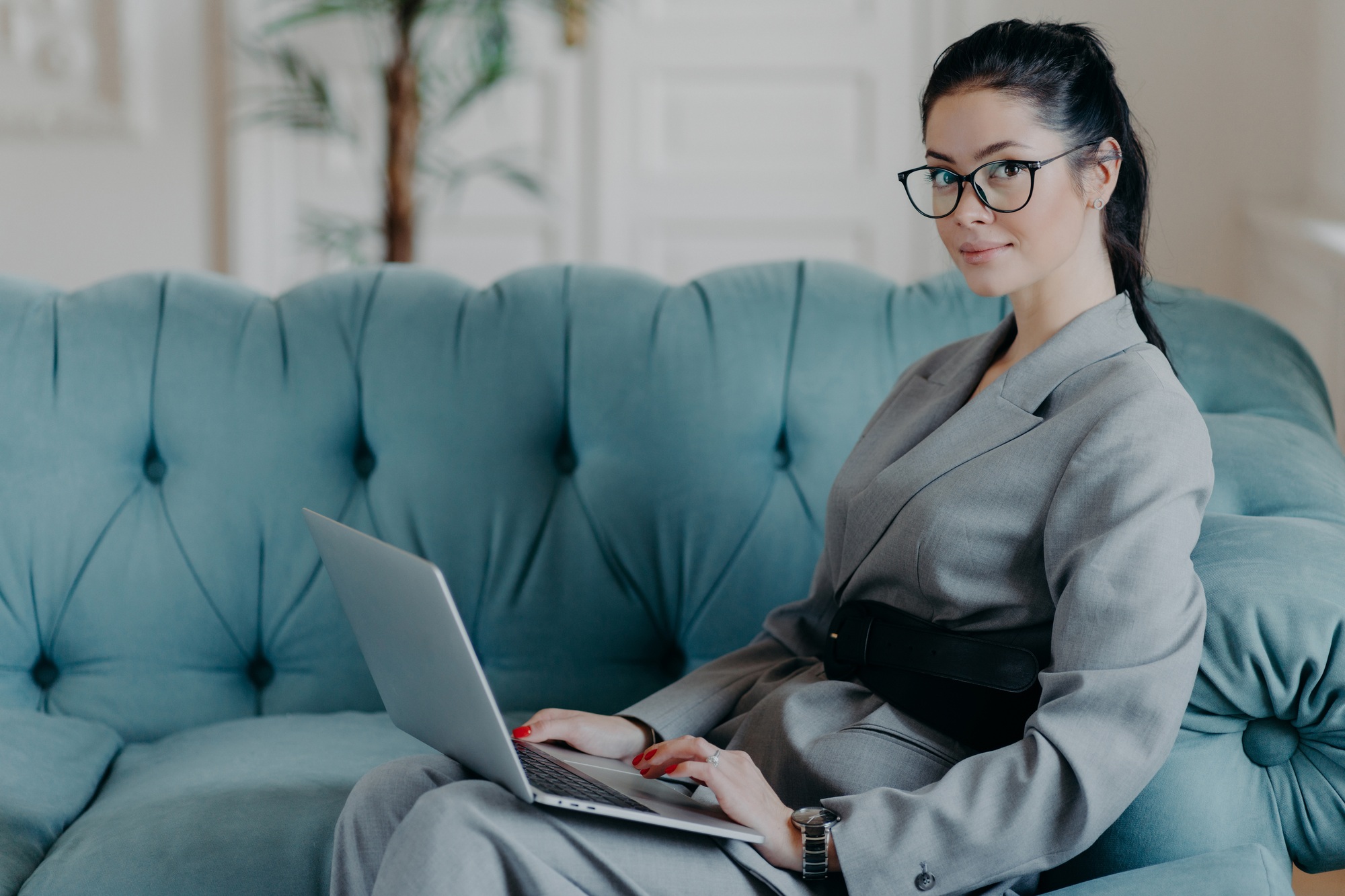 Successful female financer updates data in application on modern laptop computer