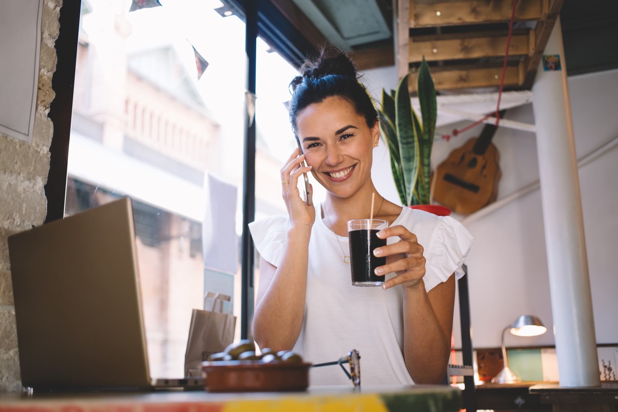 Successful freelancer calling via mobile app during remote working on netbook computer