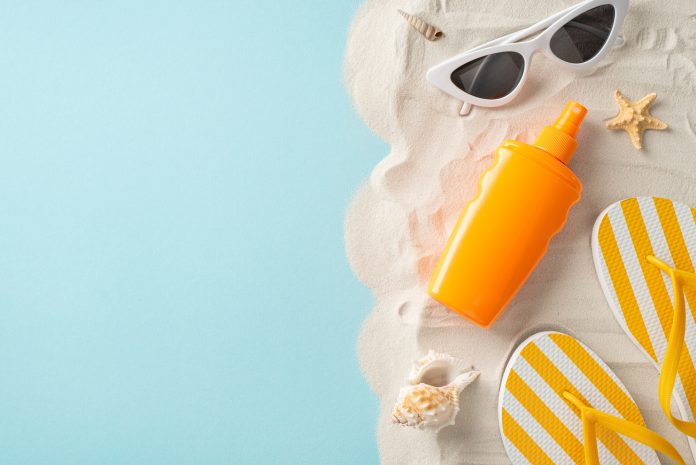Sunscreen marketing concept. Top view of unbranded sunblock lotion, paired with glasses