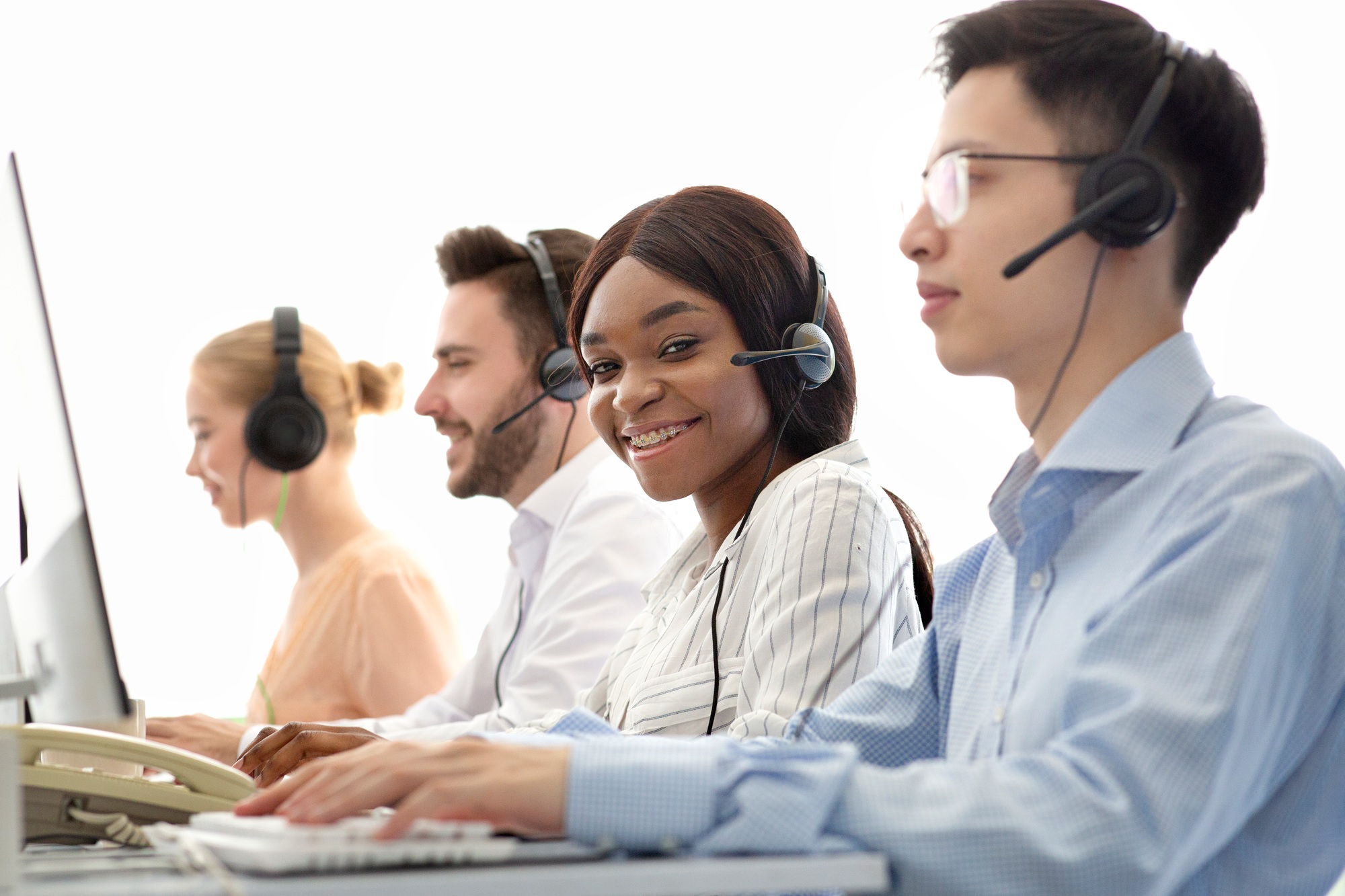 Telecommunications concept. Positive helpdesk operators selling services or goods through VoIP