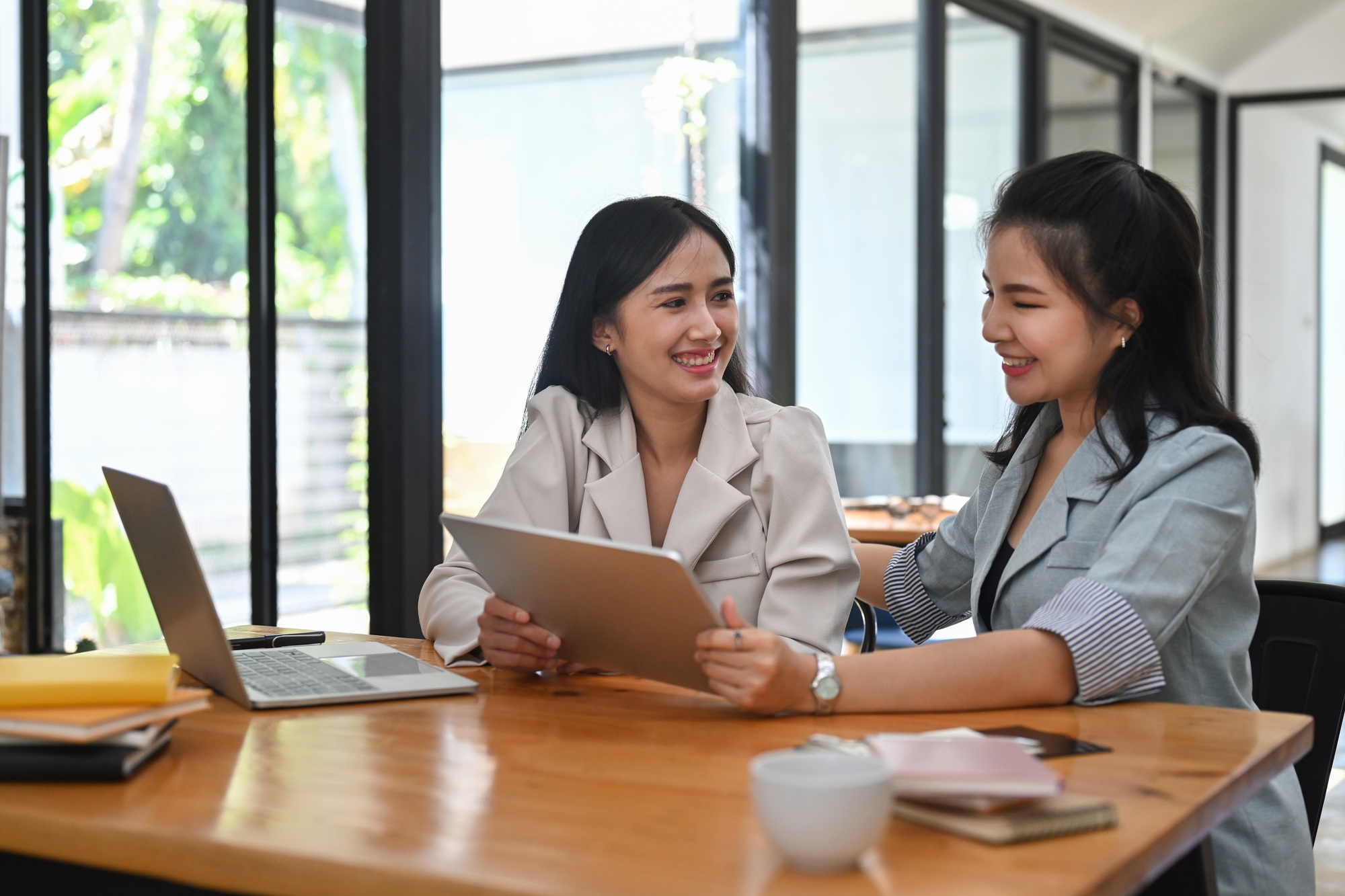 Two business women sharing ideas or startup business plan together.