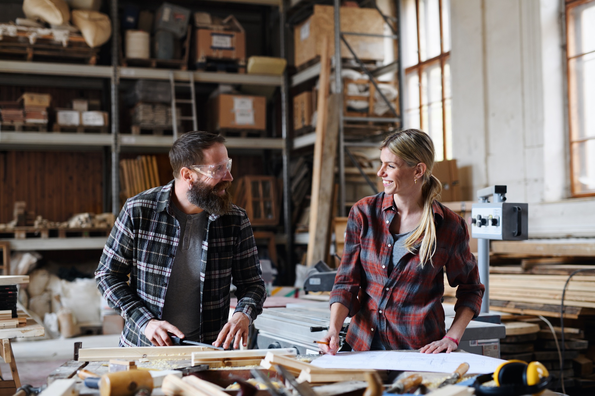 Two carpenters man and woman talking about design of products. Small business concept