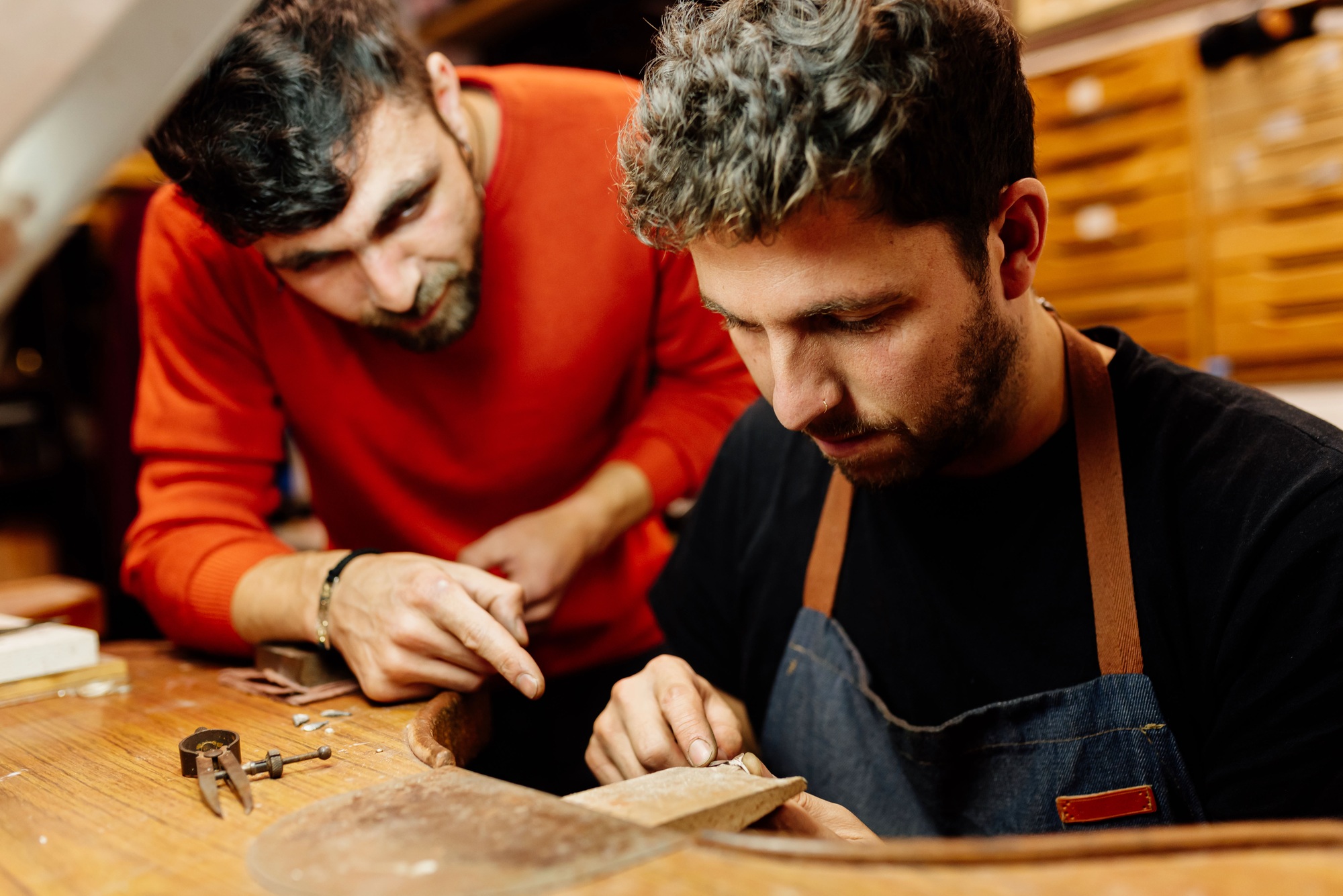 Two men work together in their small jewelry business.