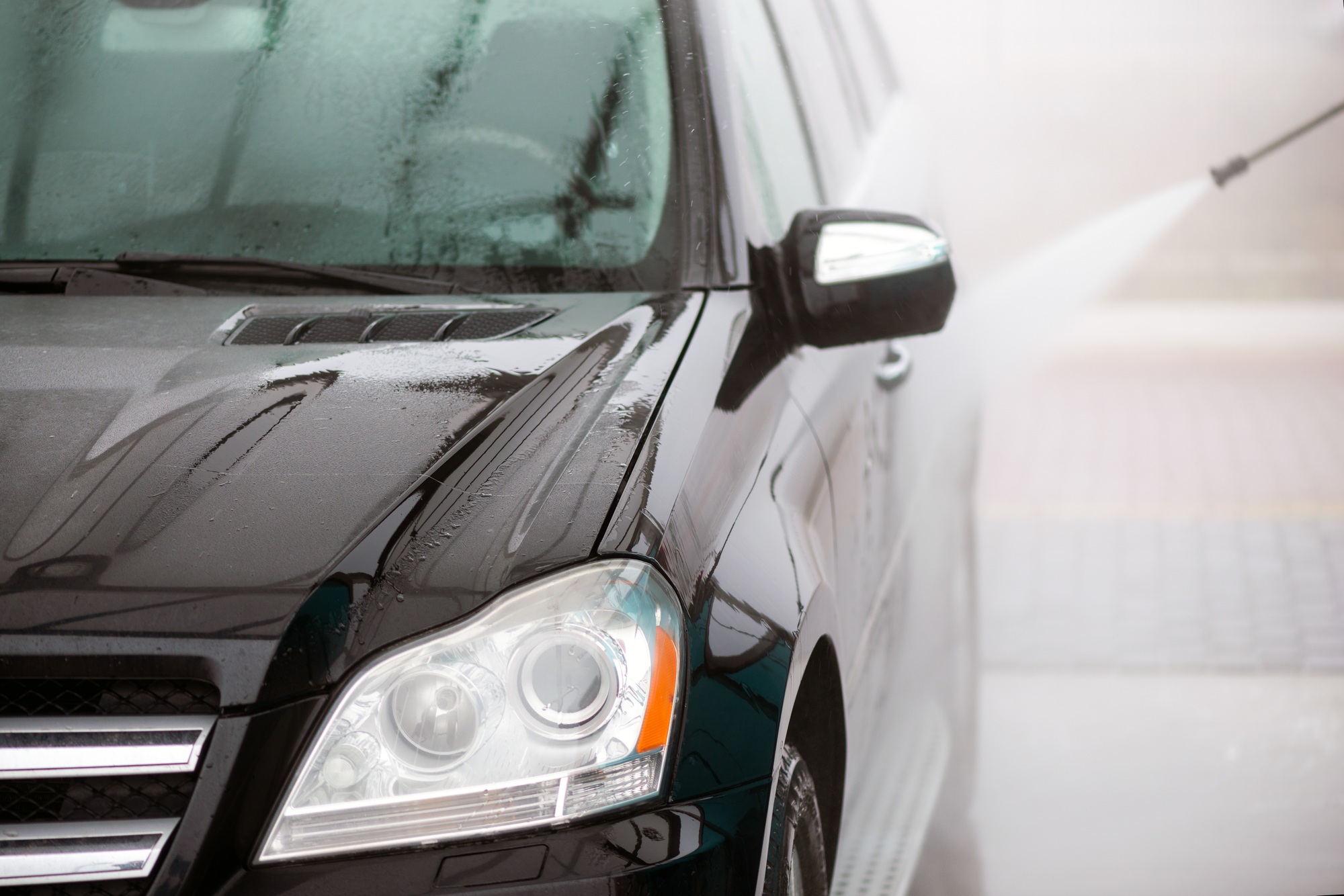 Washing car under high pressure water outdoors closeup. - Image