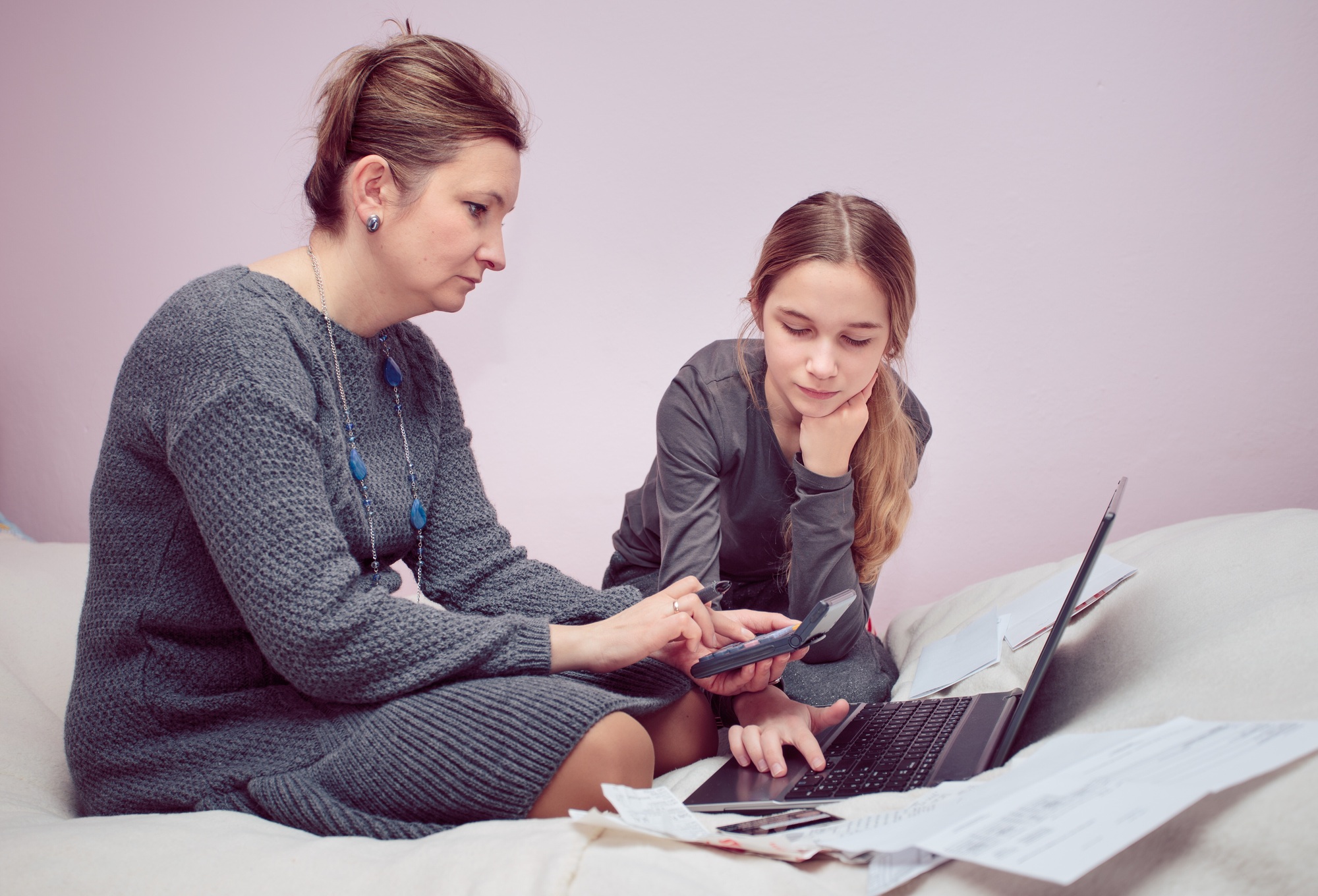 Woman and her daughter planning budget at home. Using technology. Counting budget spending money