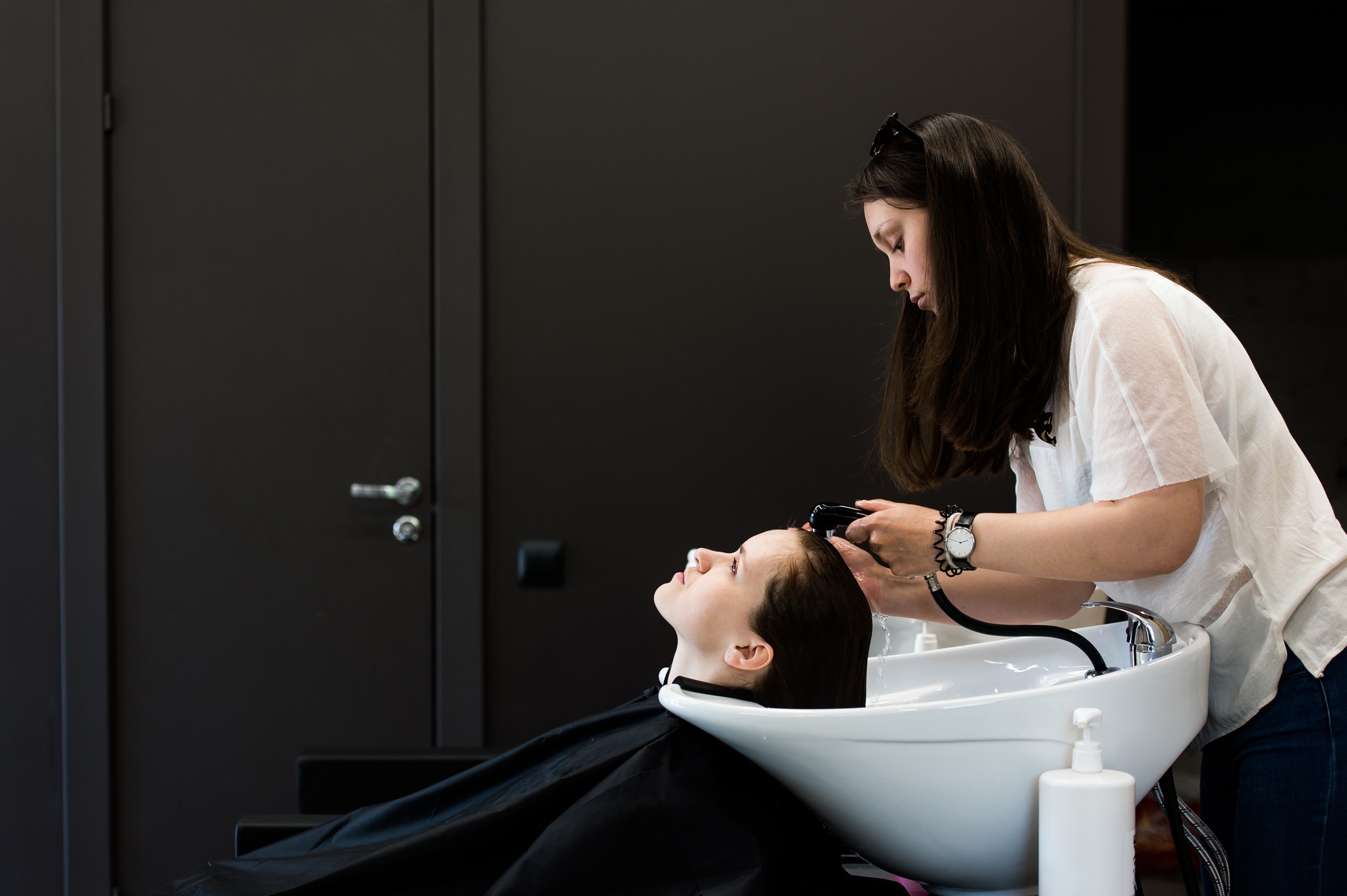 Woman at the hairdresser getting her hair washed and rinsed feeling visibly well