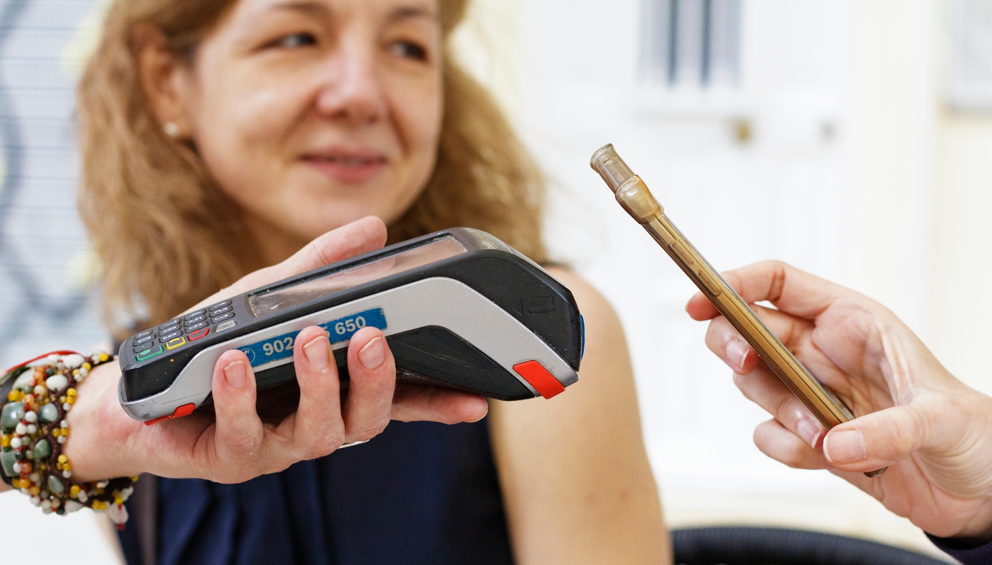 Woman paying with mobile phone, wireless terminal, payment with mobile, paying, pay phone