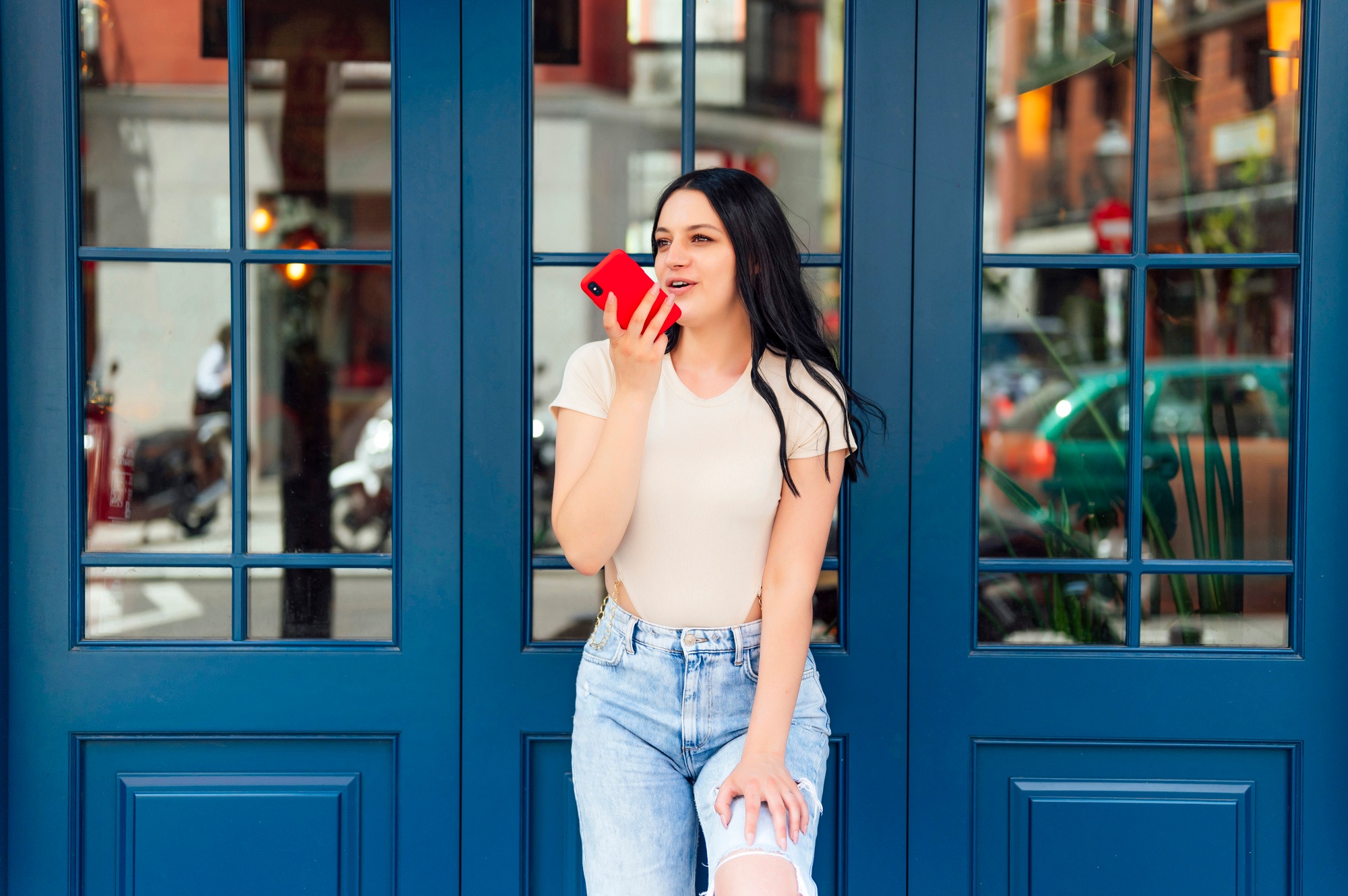 Woman with mobile phone talking on the phone while leaning on the coffee bar