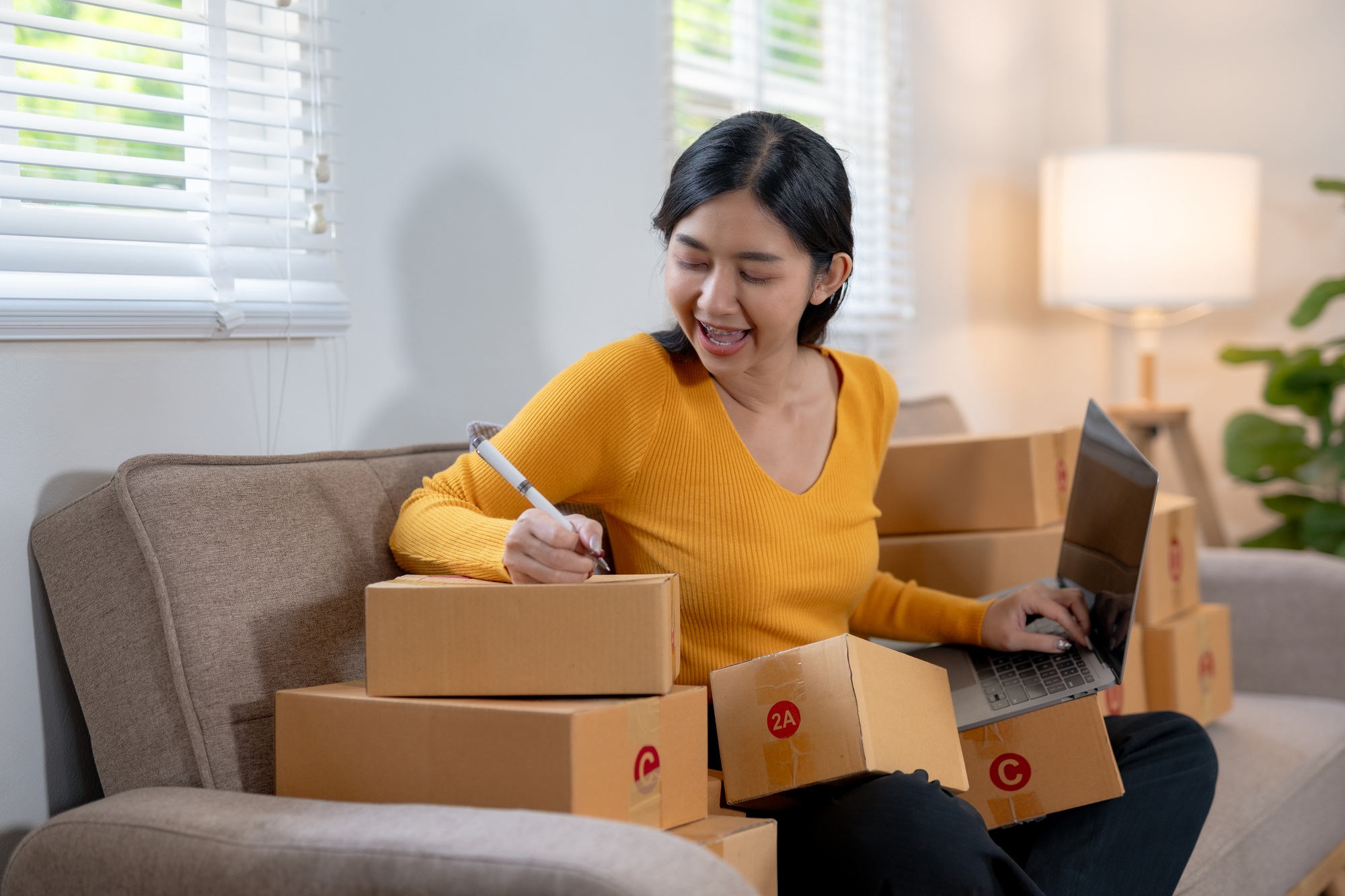 Woman working from home with multiple packages