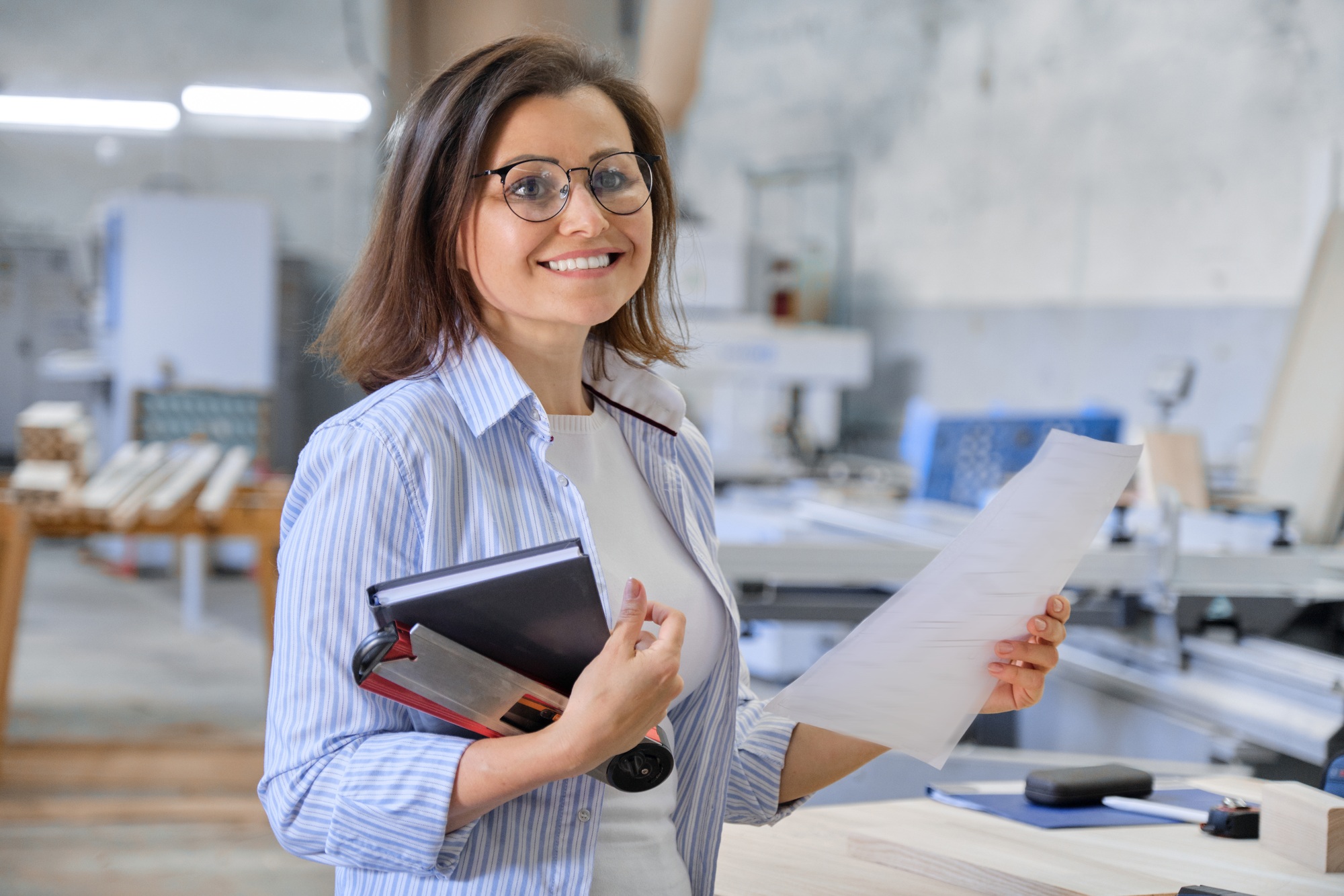 Woman working in carpentry, industrial portrait. Female in woodworking workshop