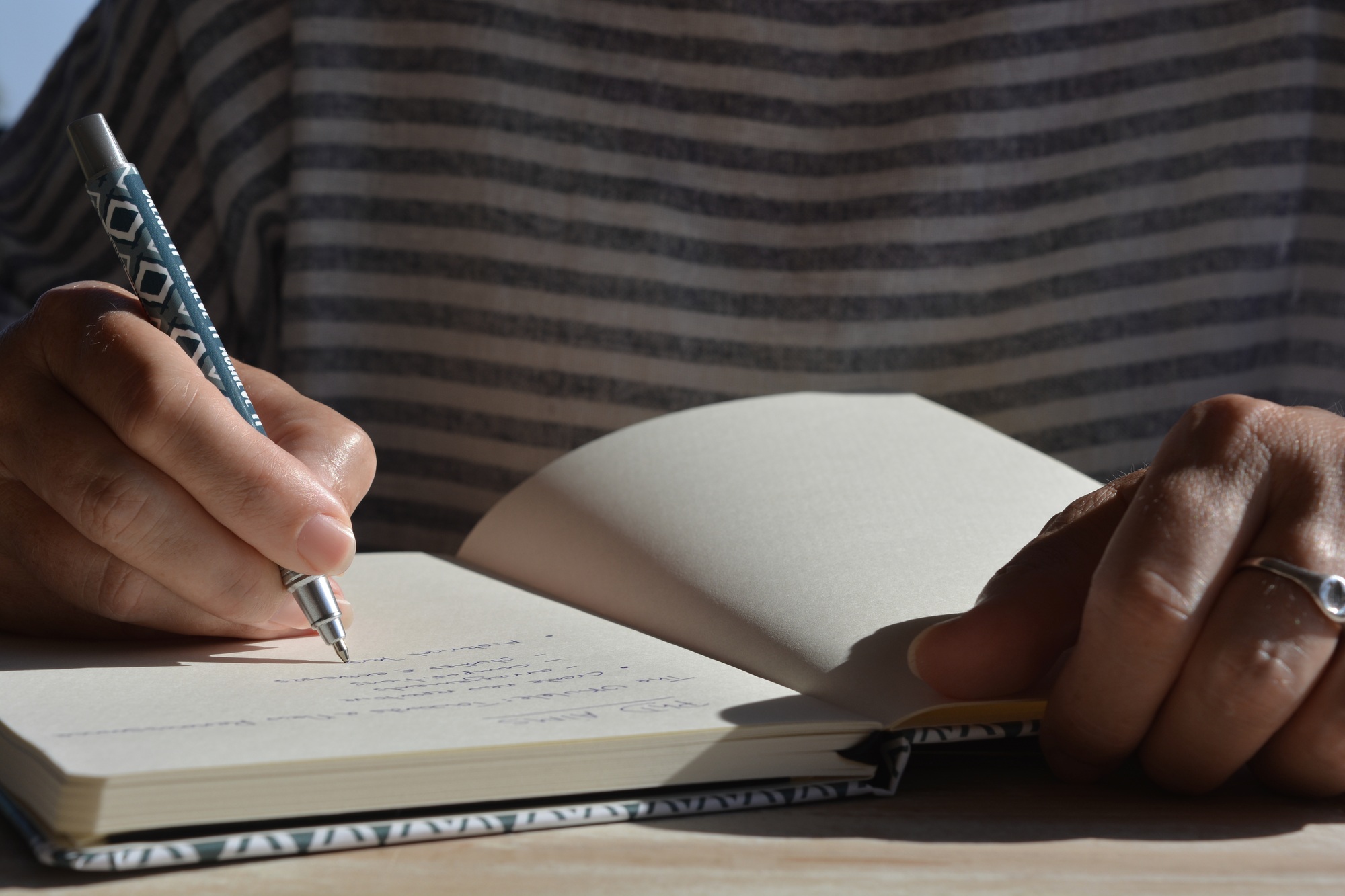 Woman writing in a journal, mid-section, low angle view