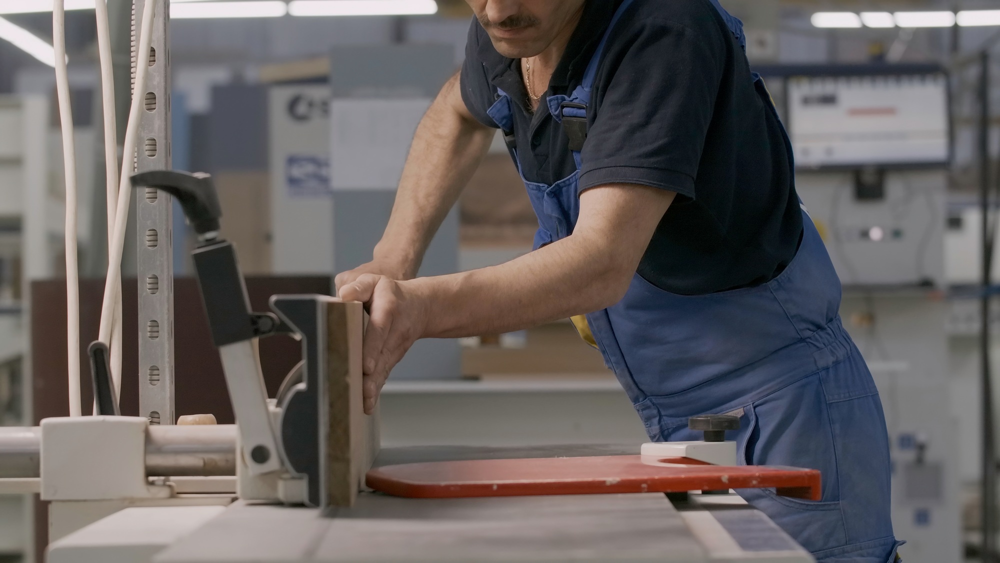 Work at the factory. Creative. Men in special clothes work with wood on special machines.