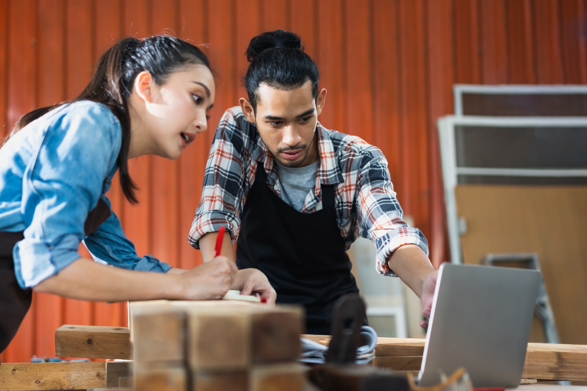 Young Asian couple carpenters man and woman discussing about design of products