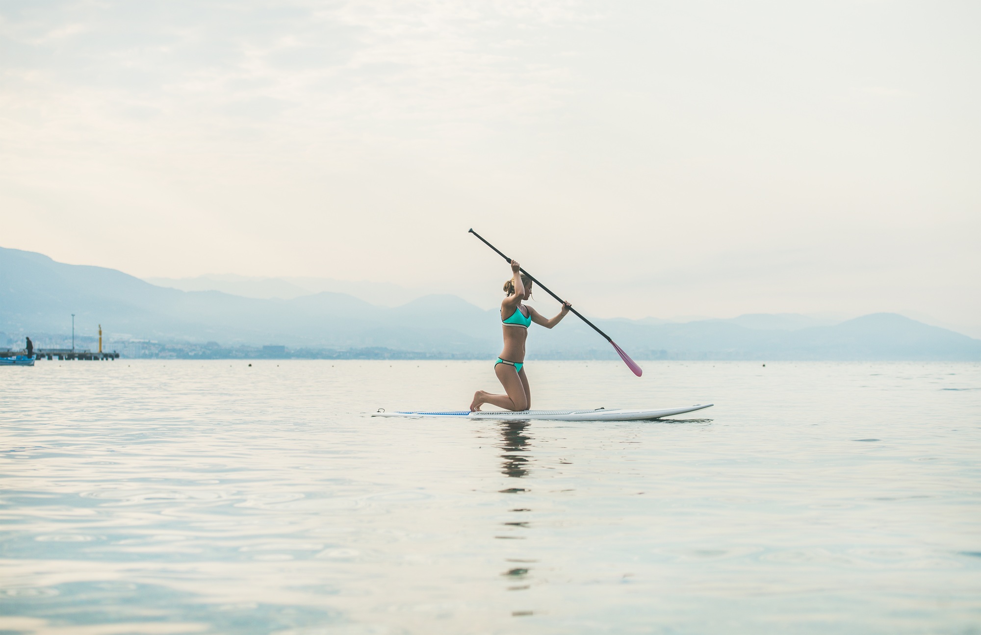 Young beautiful slavian woman tourist practicing paddle boarding