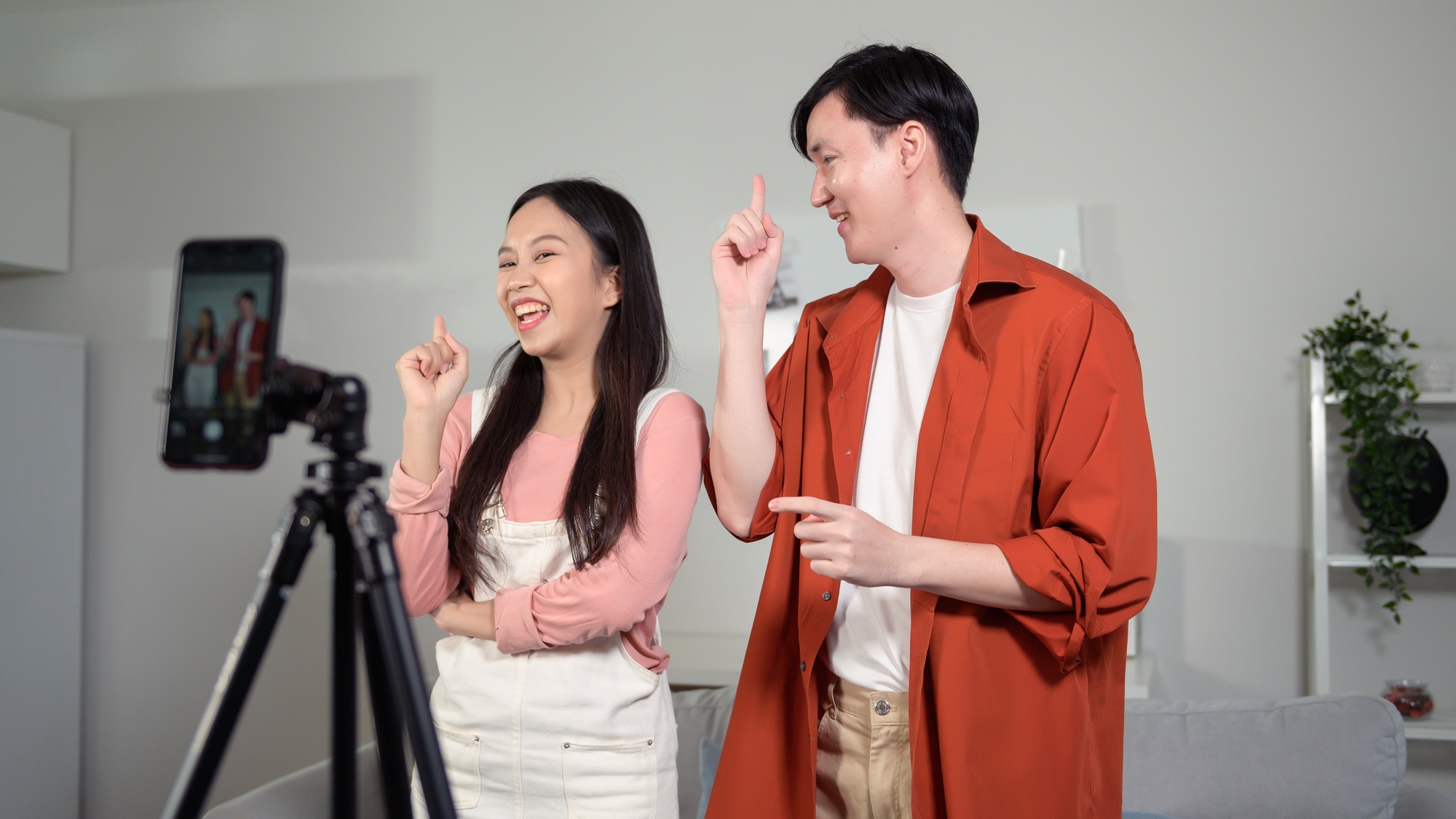 Young couple tiktokers are making video dancing  via smartphone