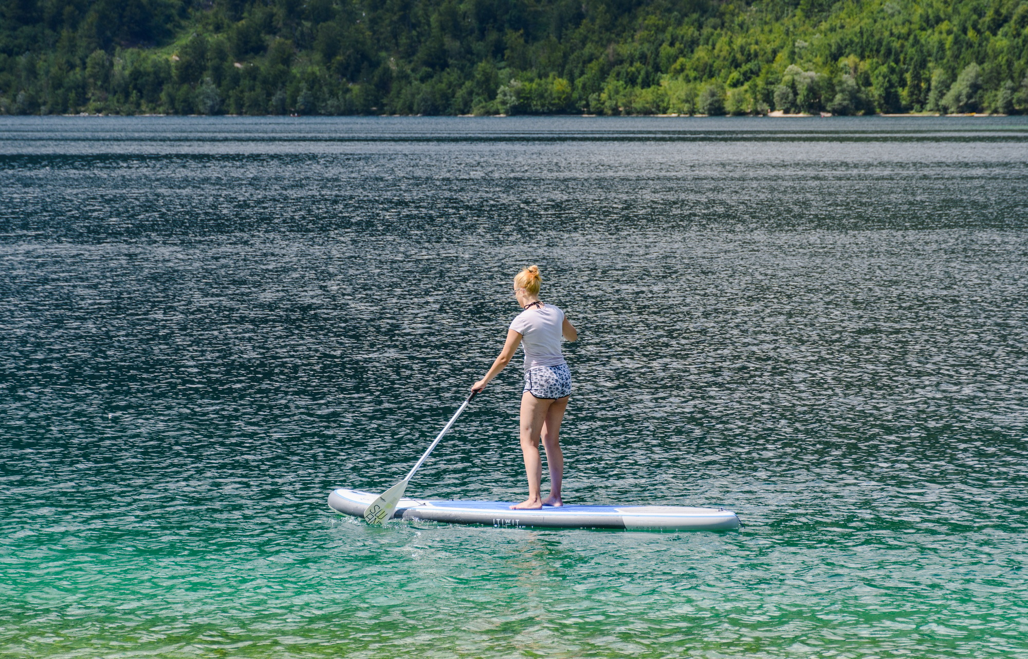 Young woman on a paddle board at a lake.