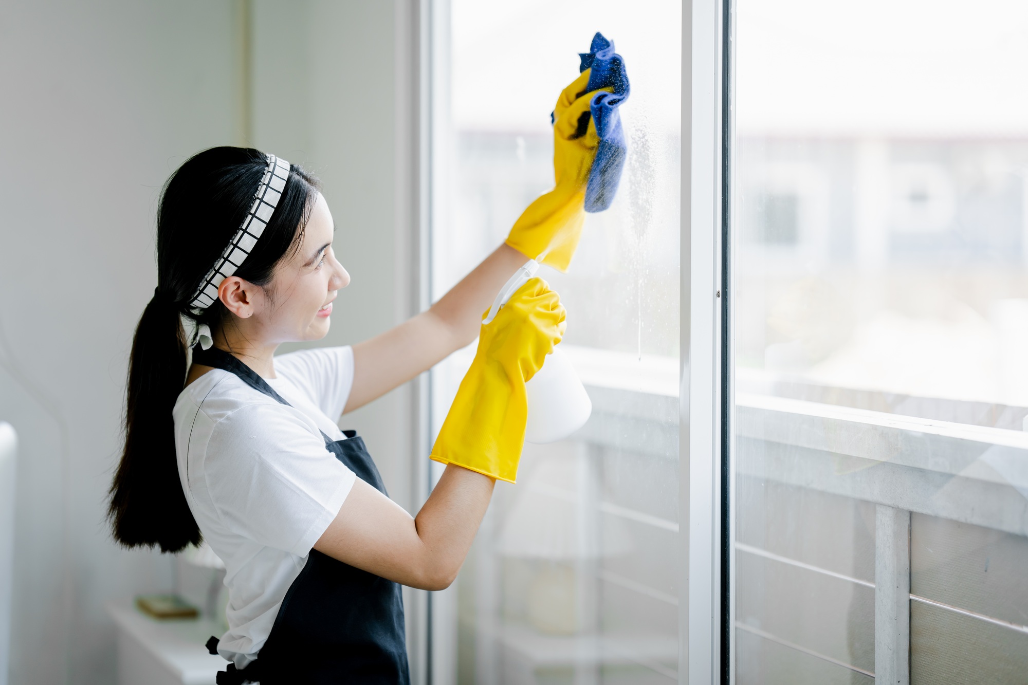 Young woman wiping clean glass at office cleaning staff cleaning concept