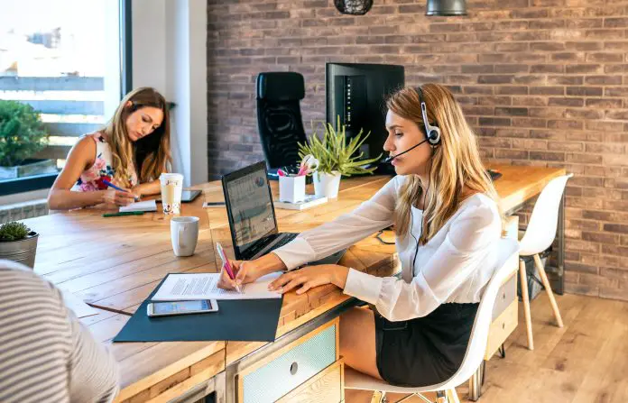 Young woman with headset in customer service of coworking